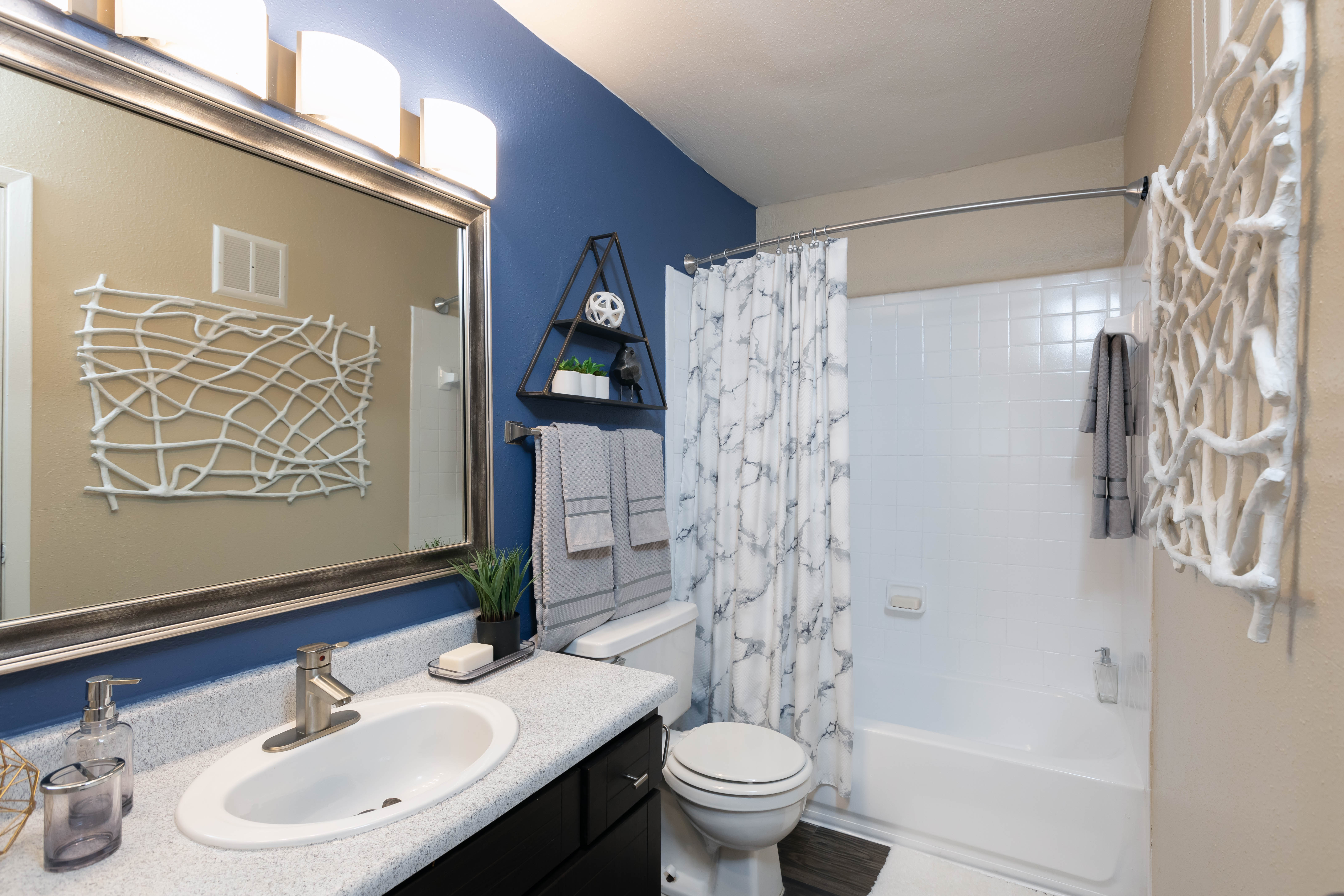 Bathroom with a large vanity mirror and an oval tub at Finley West in Houston, Texas