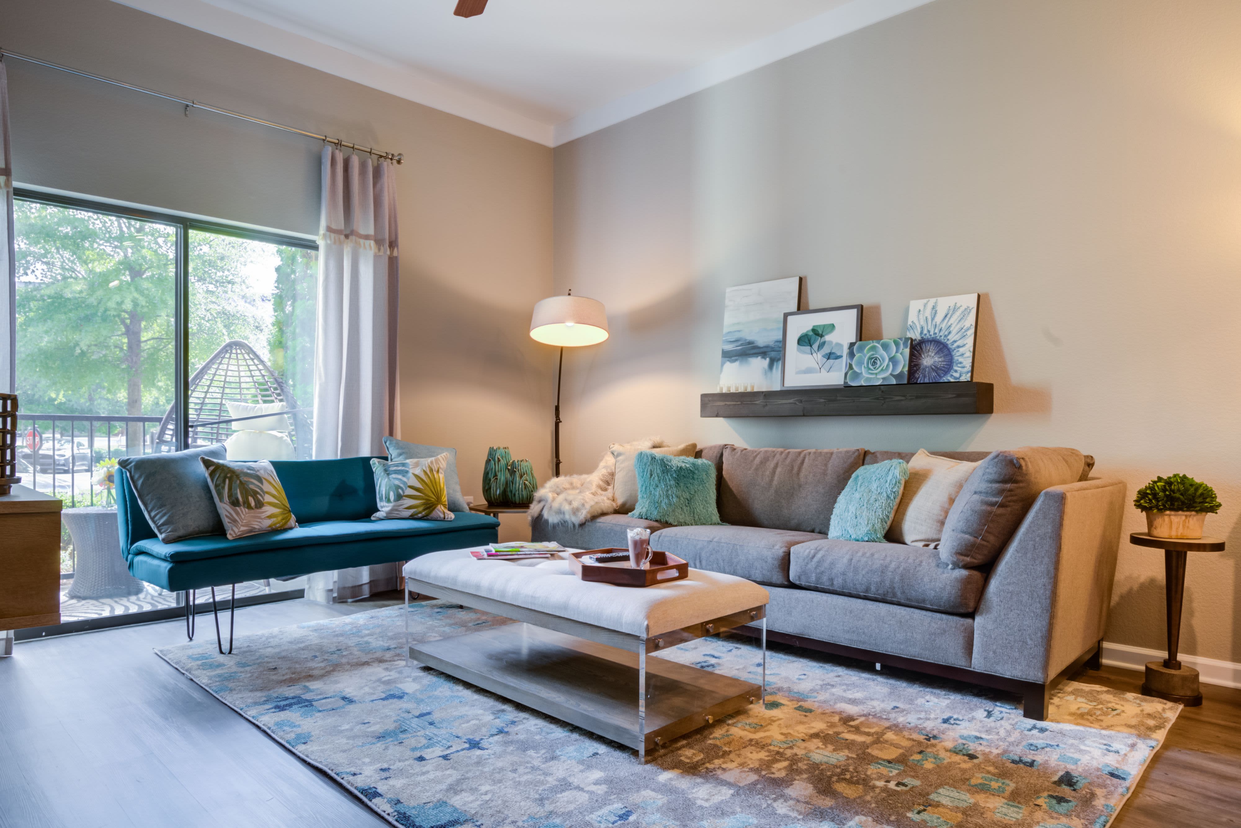 Model living room with door to balcony at Celsius Apartment Homes in Charlotte, North Carolina
