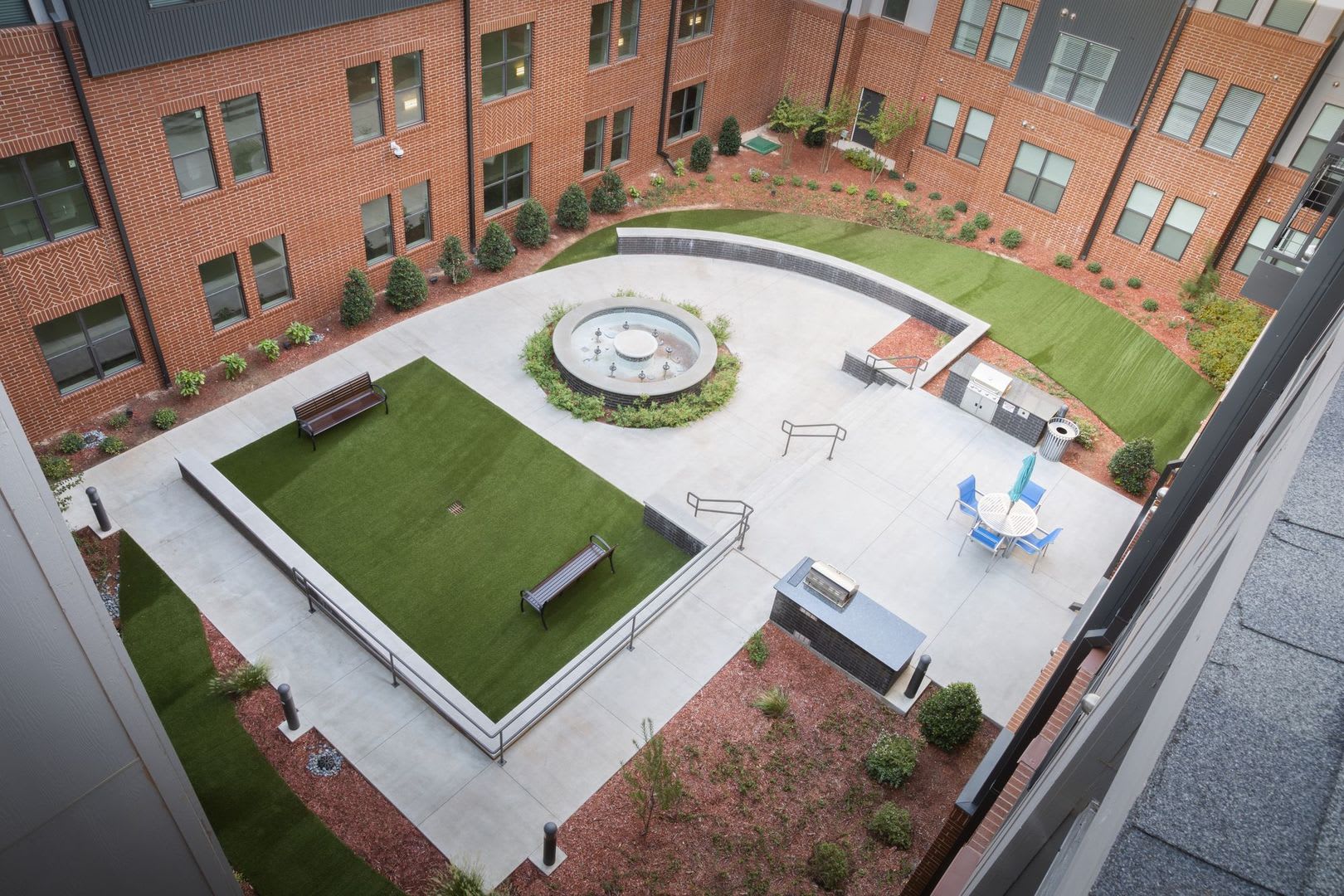 Courtyard with a grilling station, al fresco dining area and large green space at Steelyard in Oklahoma City, Oklahoma
