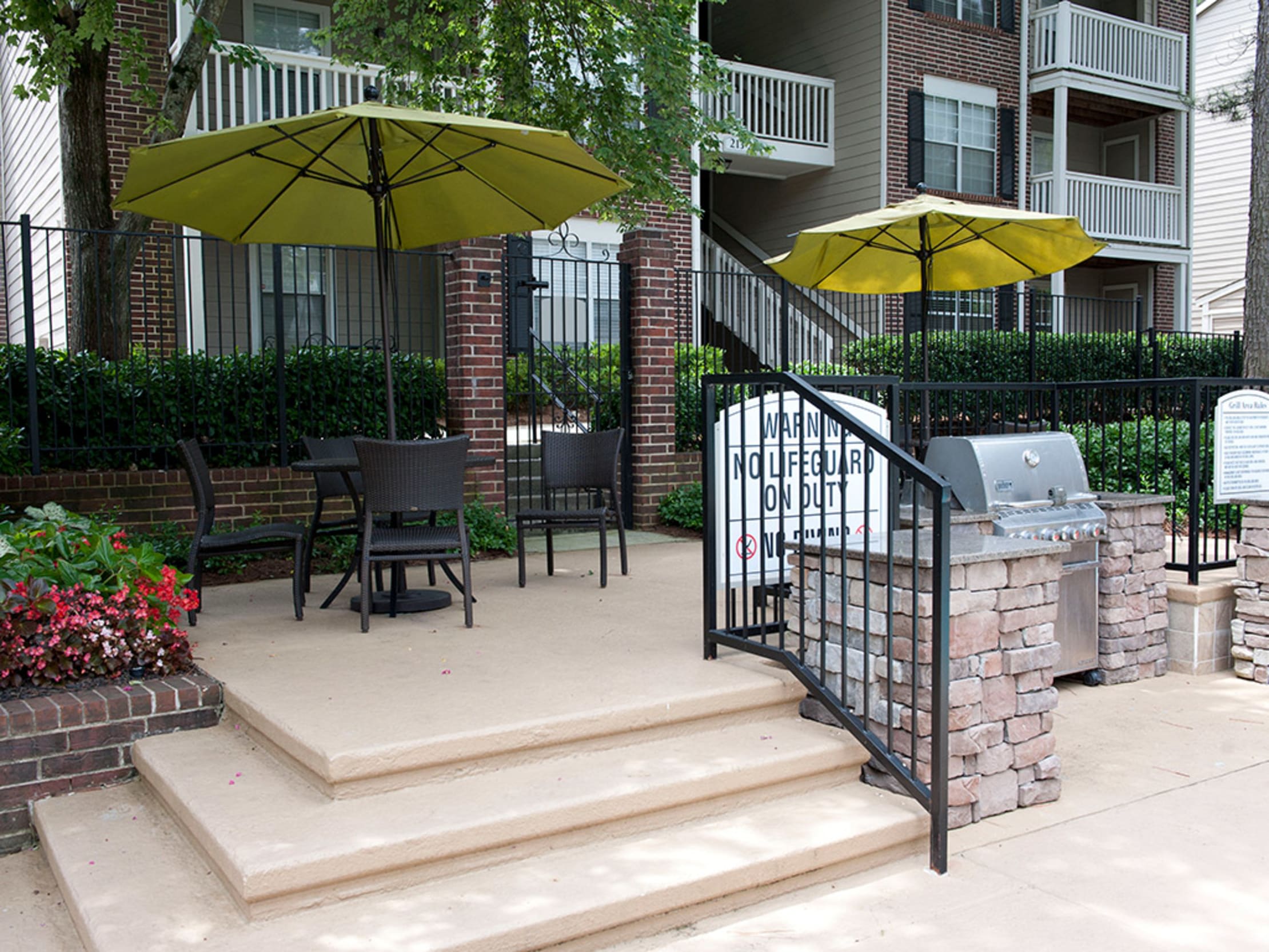 Outdoor grilling station and patio tables with umbrellas at Castlegate Collier Hills in Atlanta, Georgia