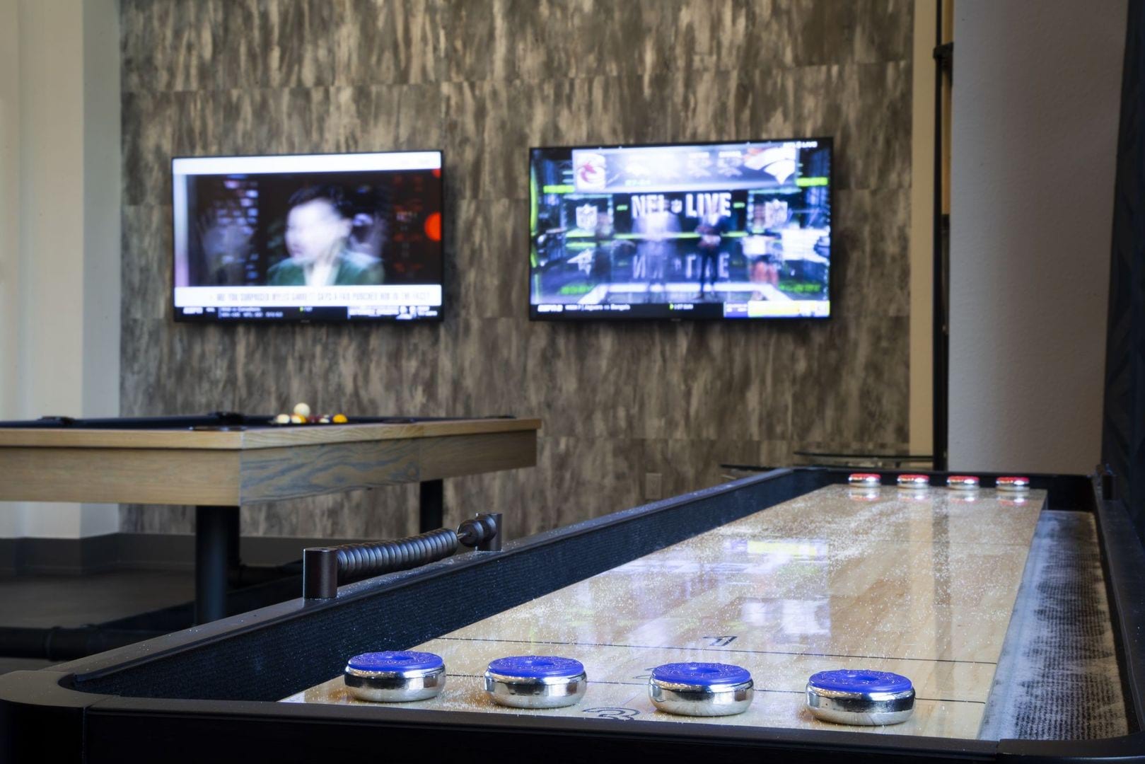 Shuffleboard table and flat screen TVs in the lounge at Steelyard in Oklahoma City, Oklahoma