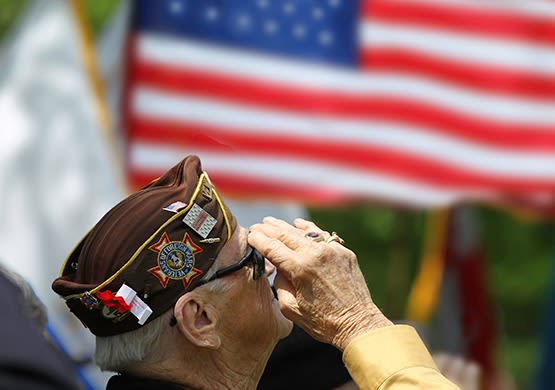 Proud senior citizen and Veteran saluting the flag. Senior veterans are welcome at our beautiful community here at Grand Villa of Boynton Beach in Florida