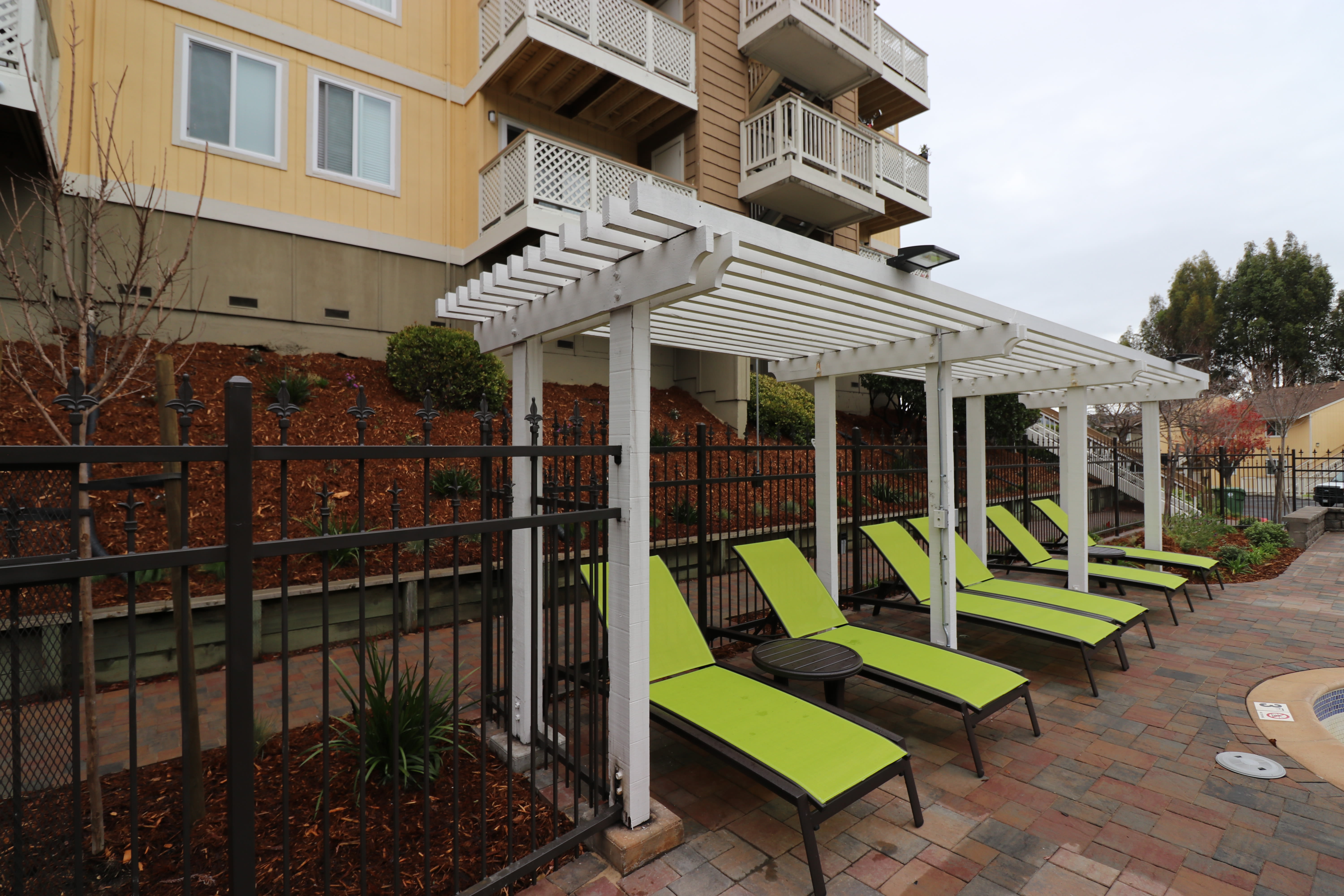 Chaise lounge chairs by the pool at Quail Hill Apartment Homes in Castro Valley, California