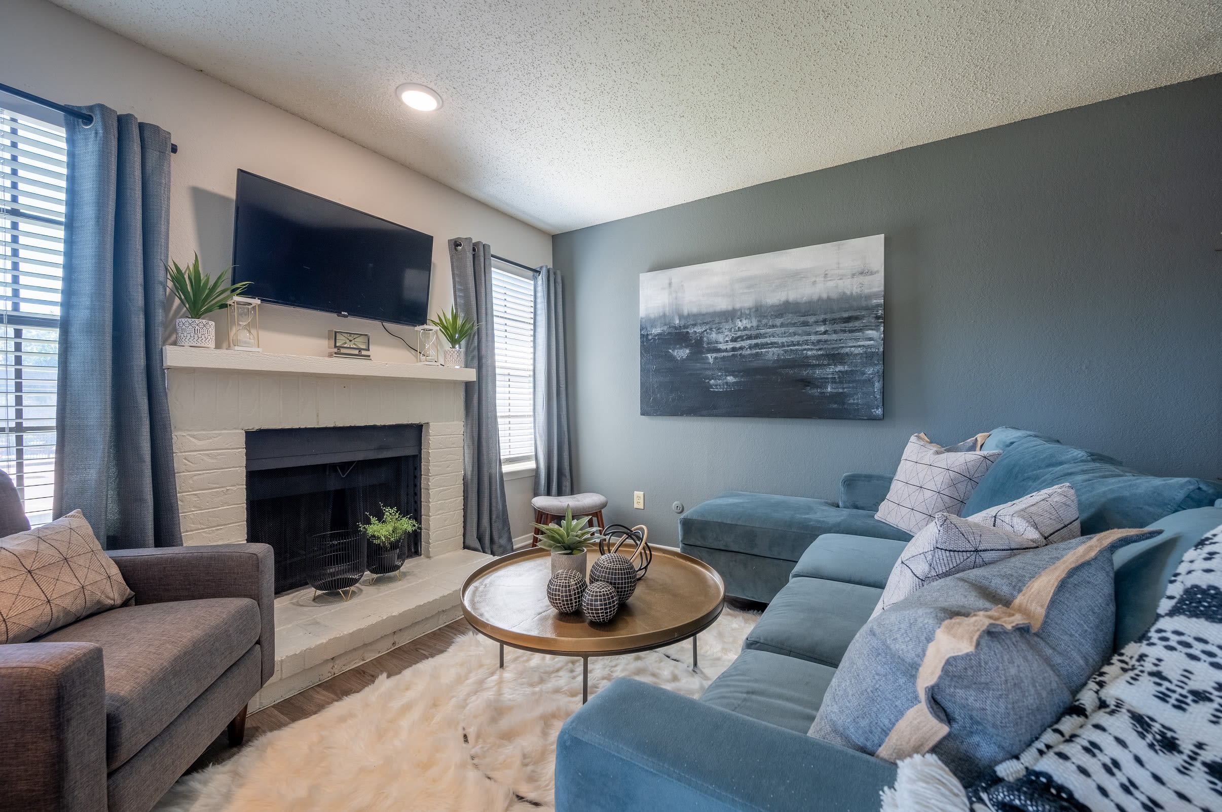 A spacious living room with a fireplace at Canopy on Central in Bedford, Texas