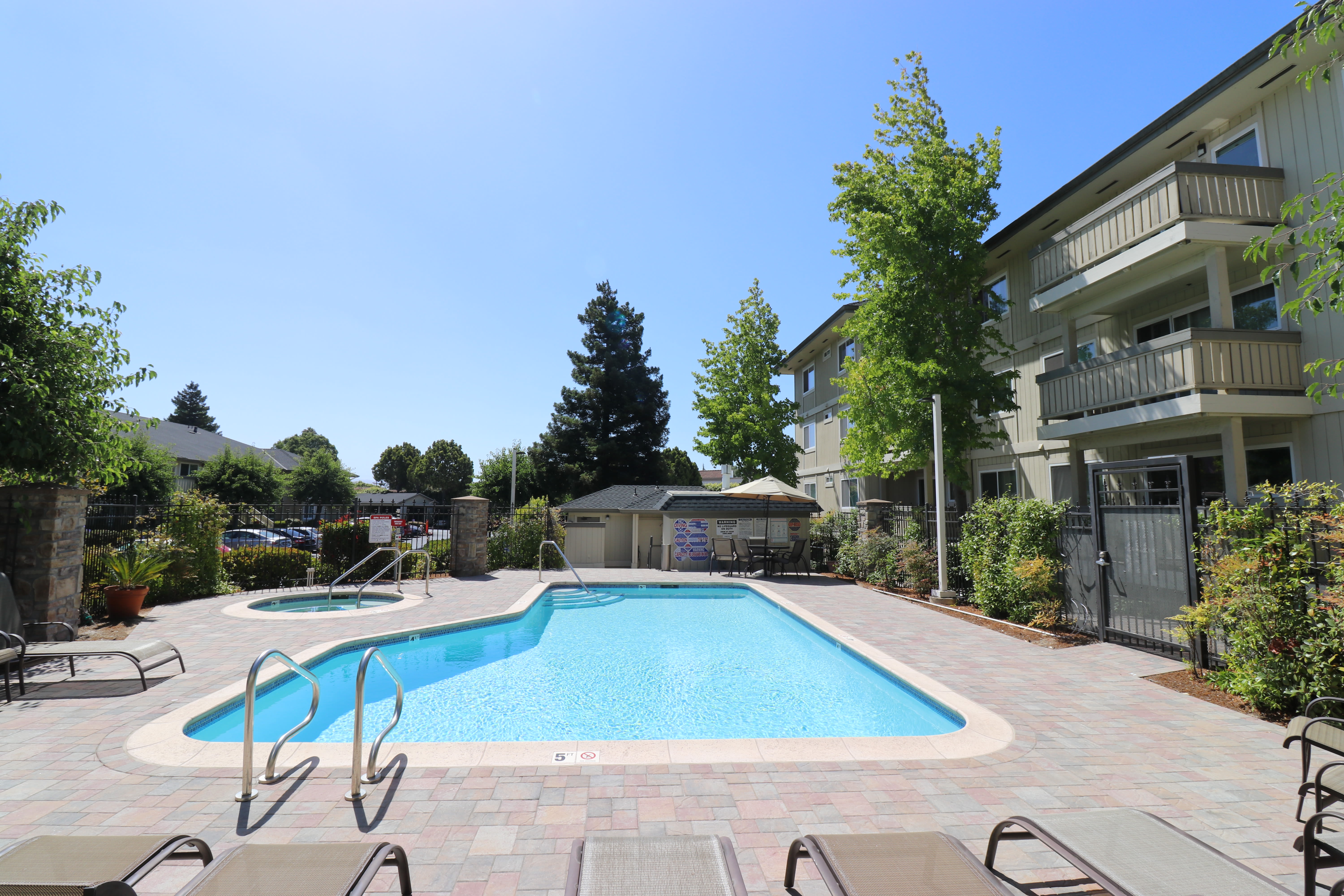 Chaise lounge chairs by the pool at Summerhill Terrace Apartment Homes in San Leandro, California
