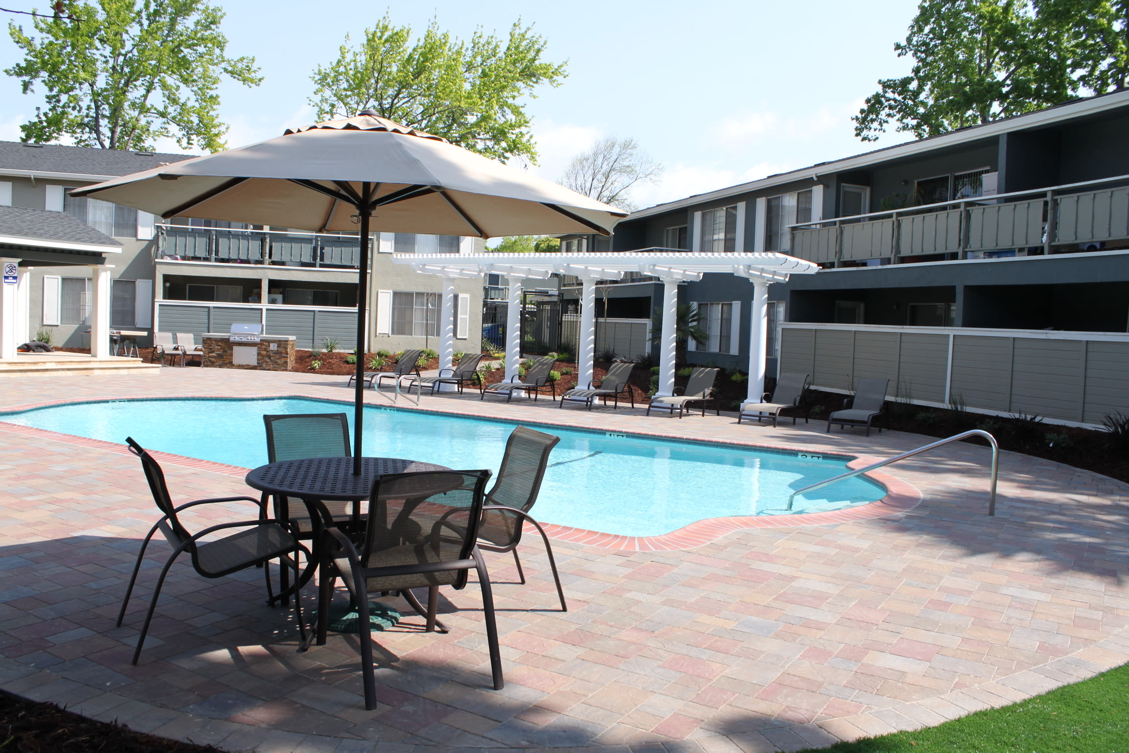 Chaise lounge chairs by the pool at Pinebrook Apartment Homes in Fremont, California