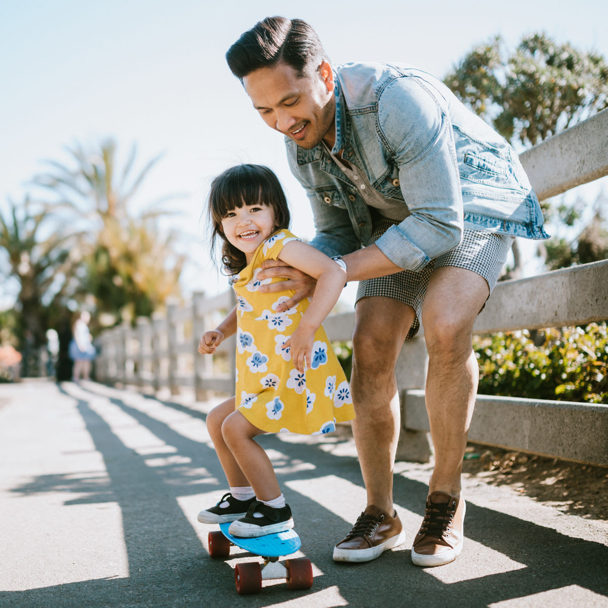 A resident helping his daughter skateboard at Aero Ridge in San Diego, California