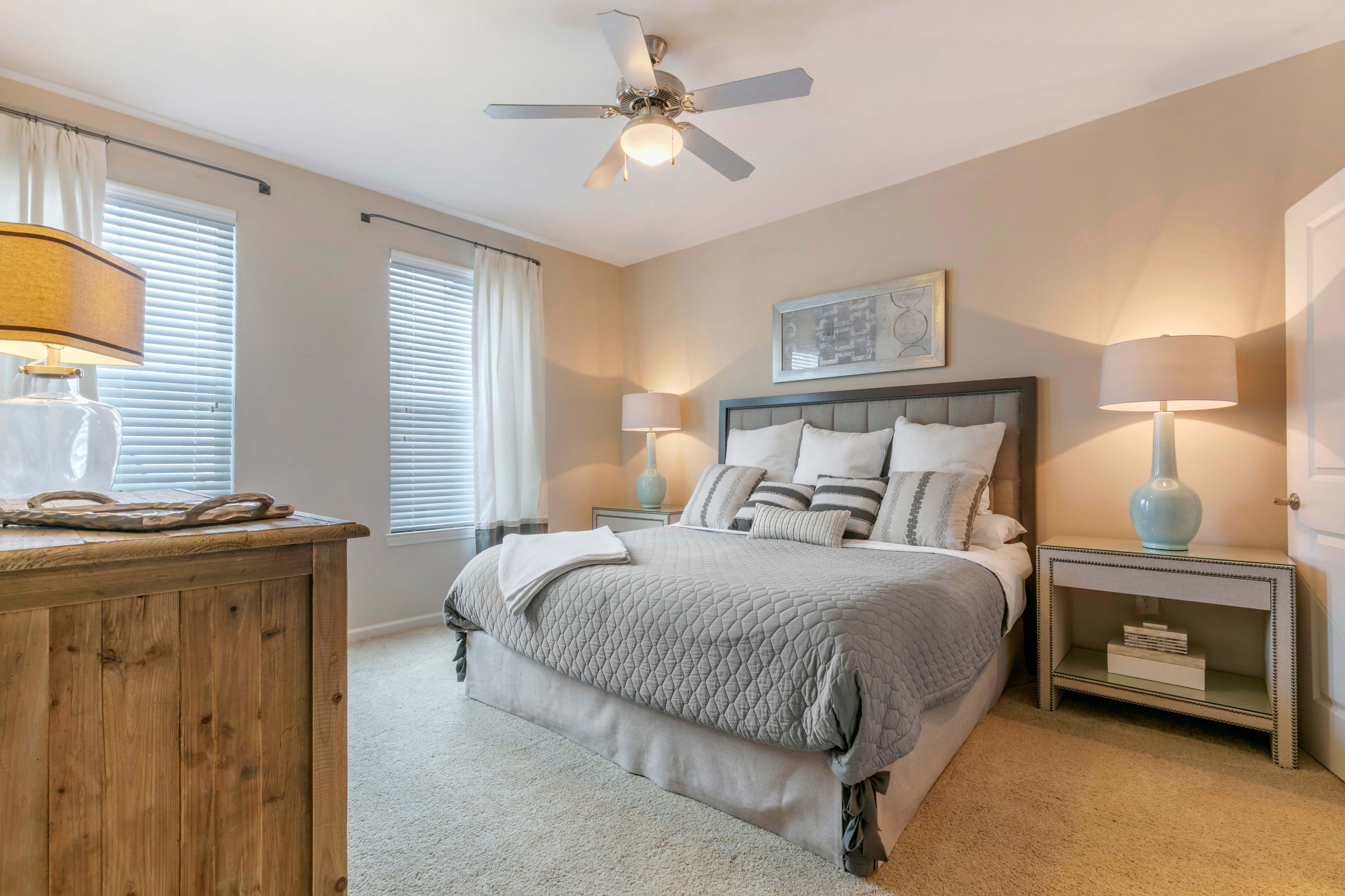 Model bedroom with a ceiling fan and plush carpeting at The Village at Apison Pike in Ooltewah, Tennessee