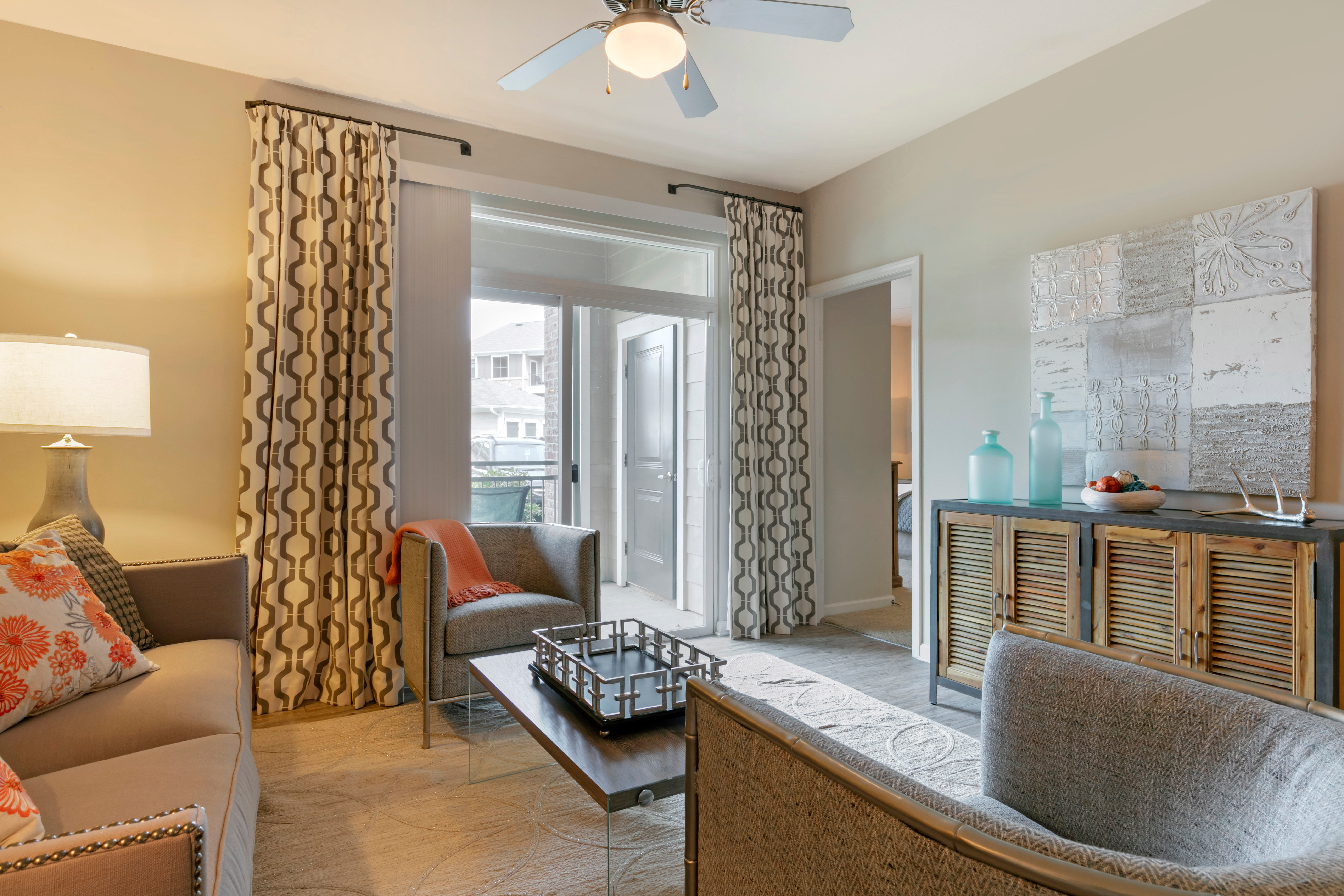 Living room opening onto a private balcony in a model home at The Village at Apison Pike in Ooltewah, Tennessee