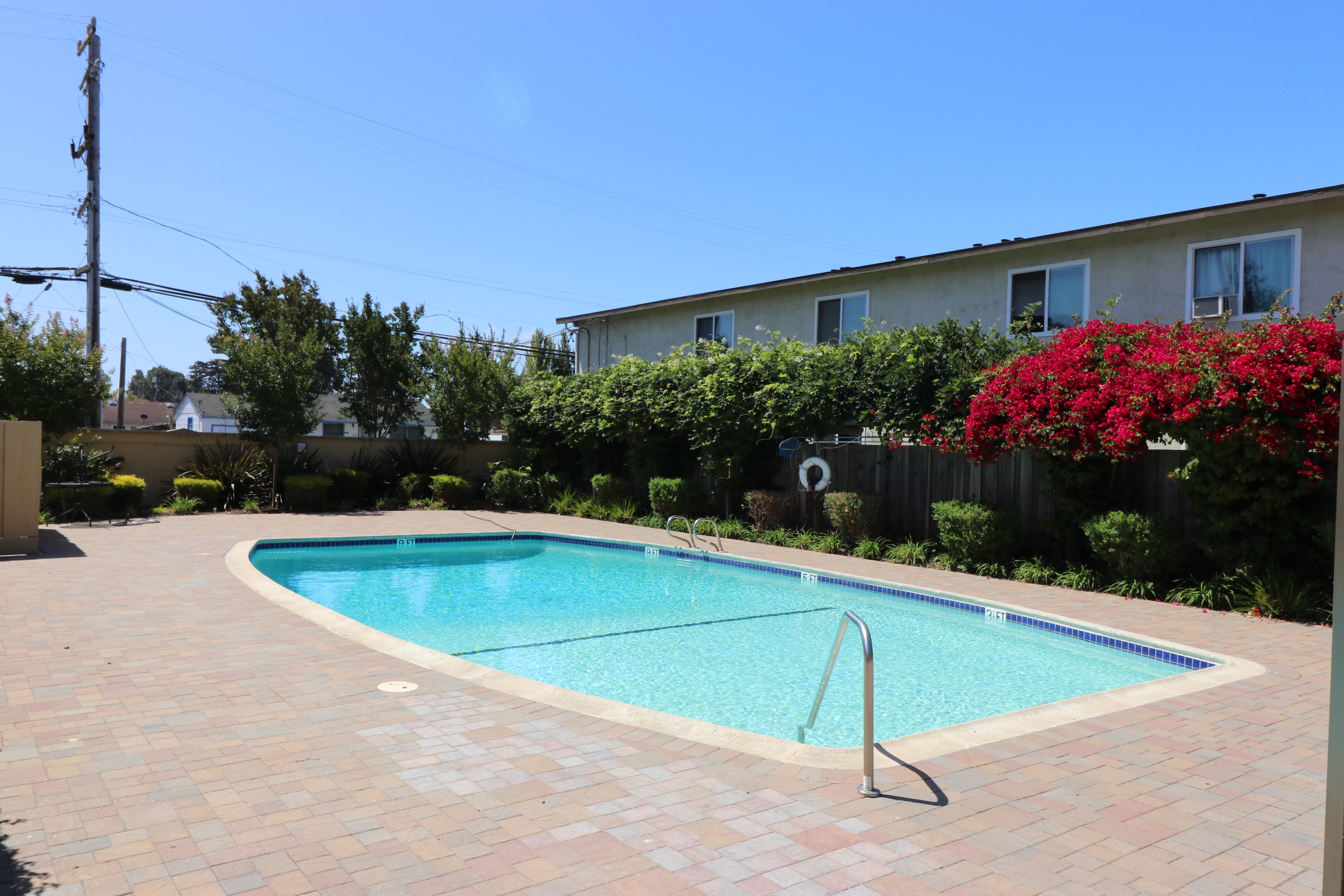 Chaise lounge chairs by the pool at Marina Plaza Apartment Homes in San Leandro, California