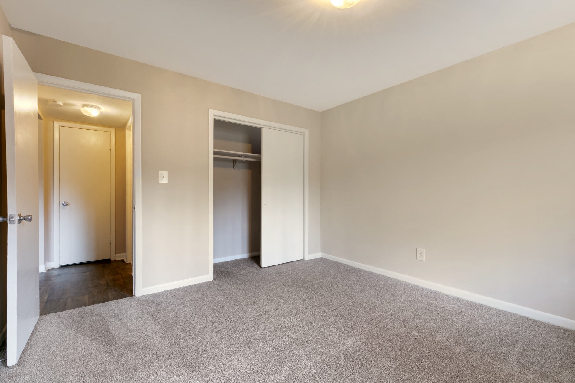 Carpeted bedroom with closet at Galleria Courtyards in Smyrna, Georgia