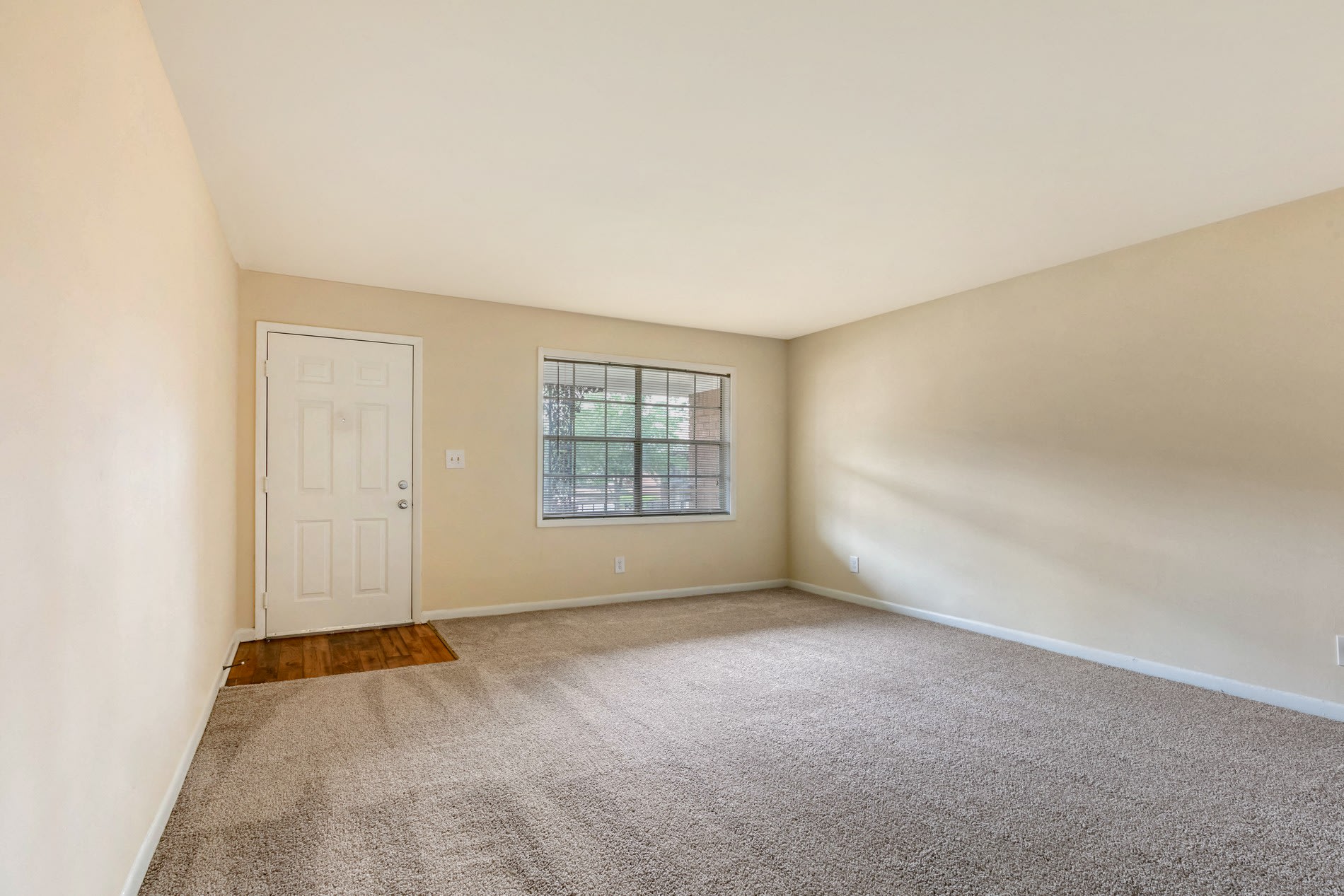 Carpeted bedroom with exterior door at Galleria Courtyards in Smyrna, Georgia