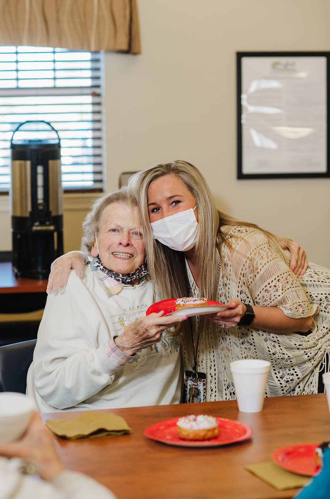Resident smiling with a plated donut in her hand at English Meadows Blacksburg Campus in Blacksburg, Virginia
