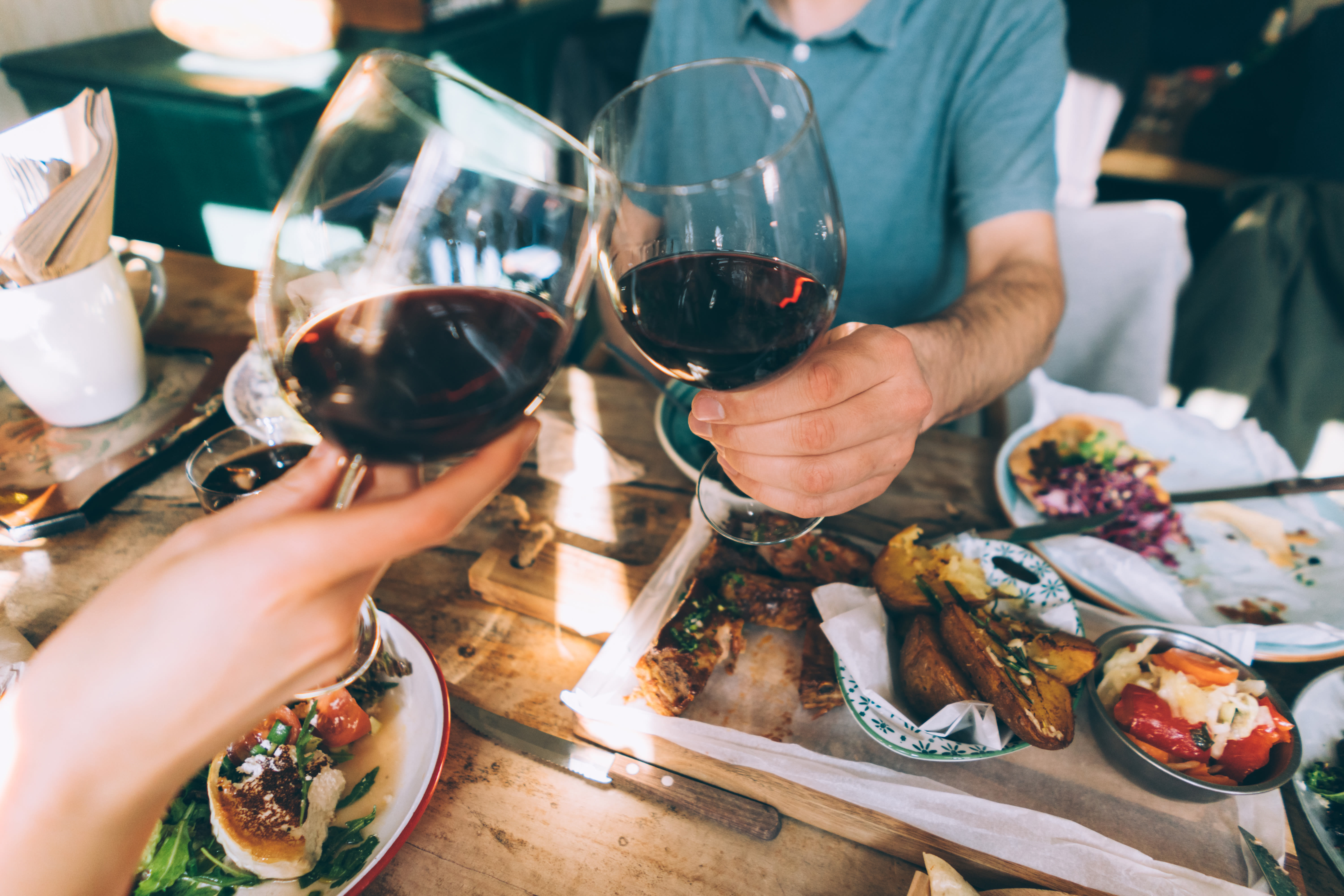 Two residents clink their wine glasses together over a meal in Seattle, Washington