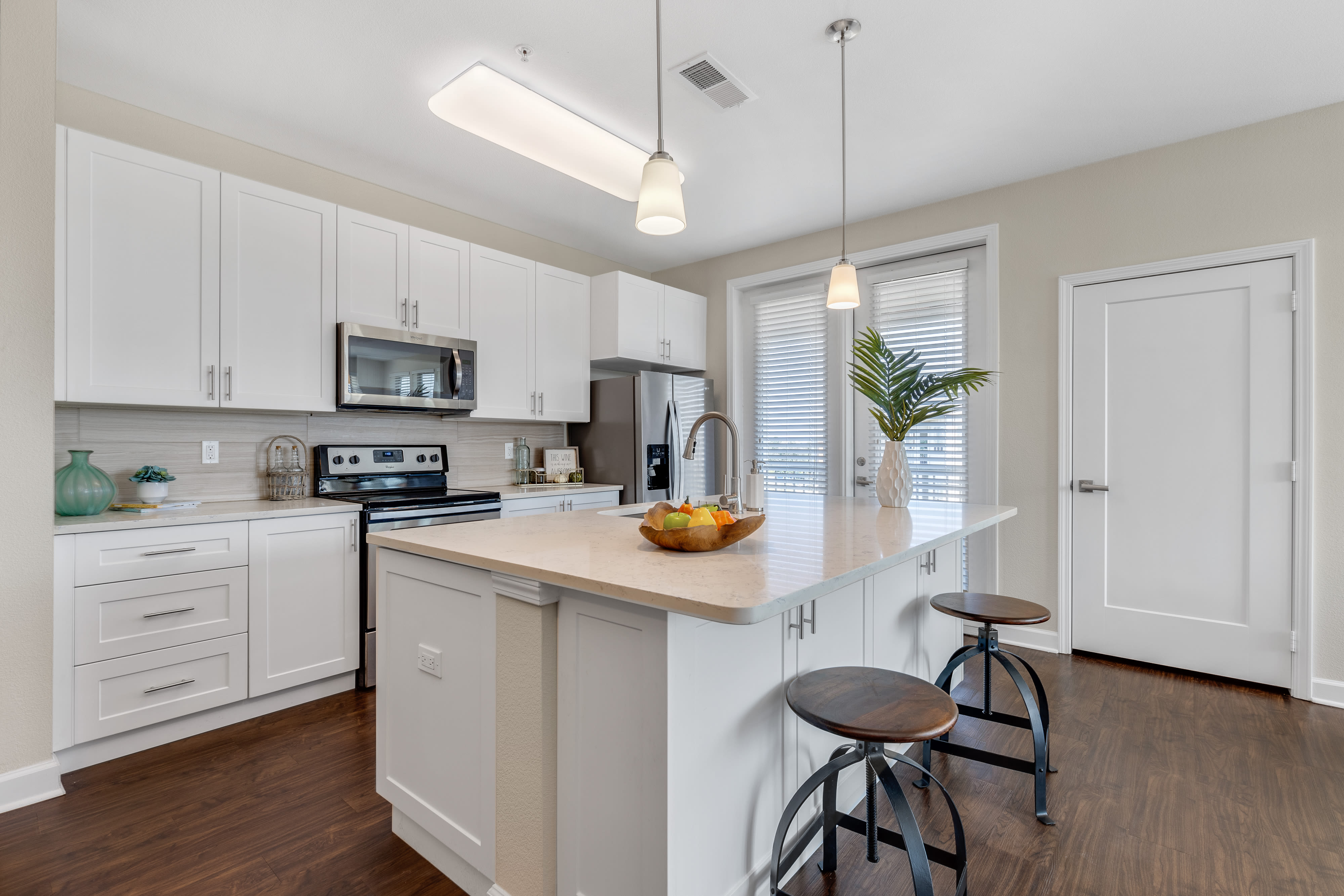 Model kitchen with a large island and quartz countertops at The Point at Town Center in Jacksonville, Florida
