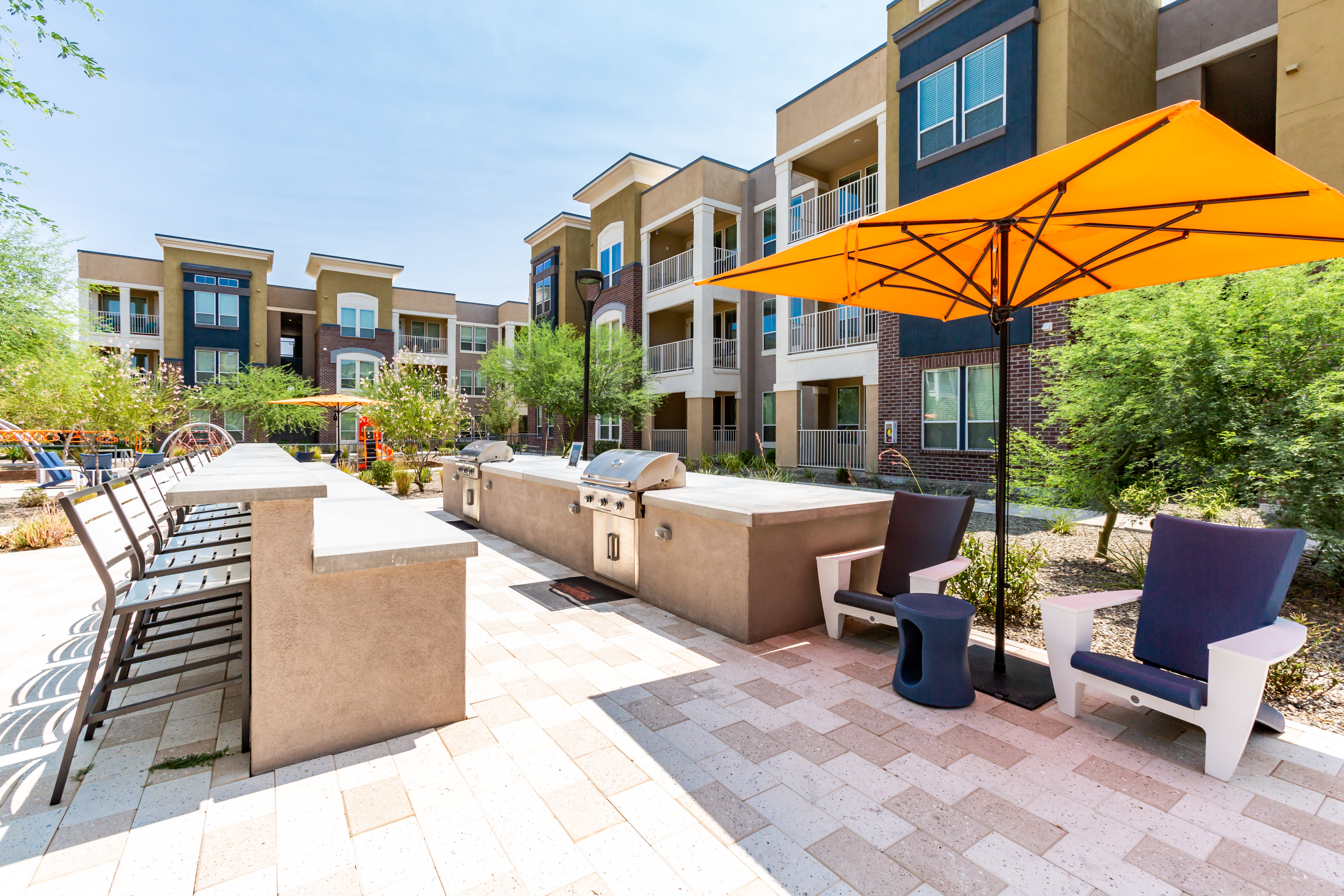 BBQ grills and counter seating in the outdoor lounge at Town Commons in Gilbert, Arizona