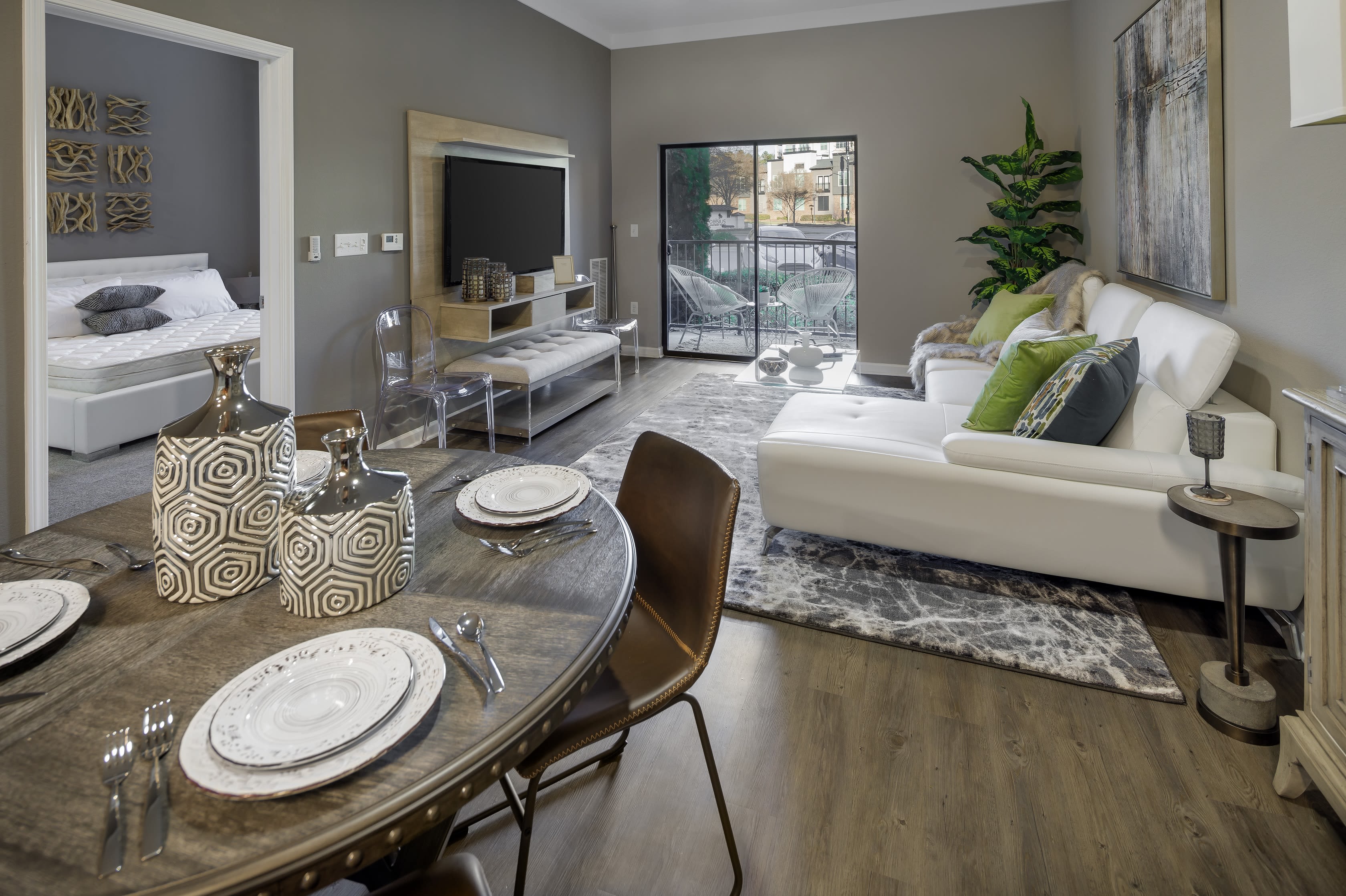 Well-furnished model home's dining and living area at Celsius Apartment Homes in Charlotte, North Carolina