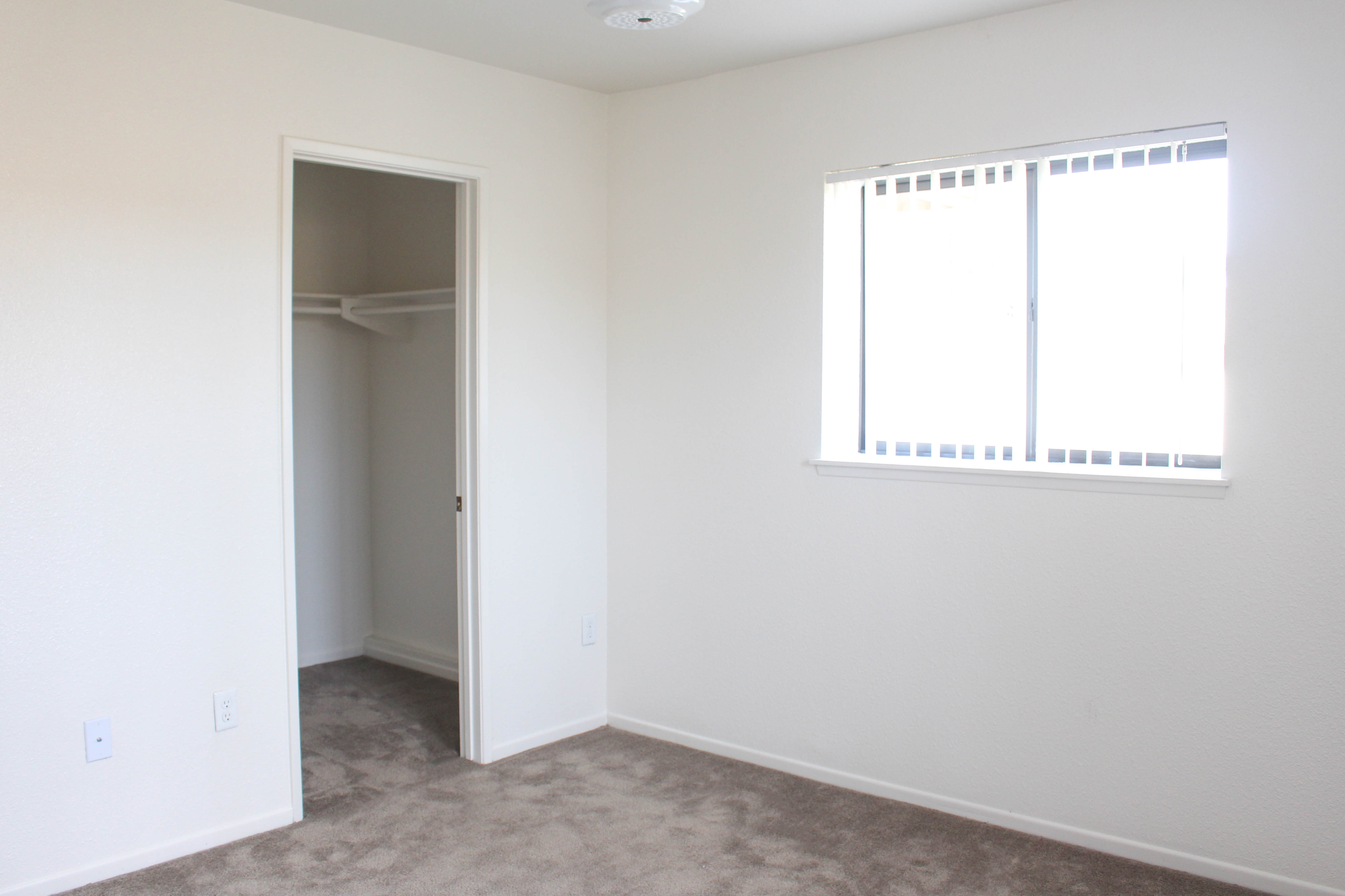 A bedroom with a walk-in closet at Miramar Townhomes in San Diego, California