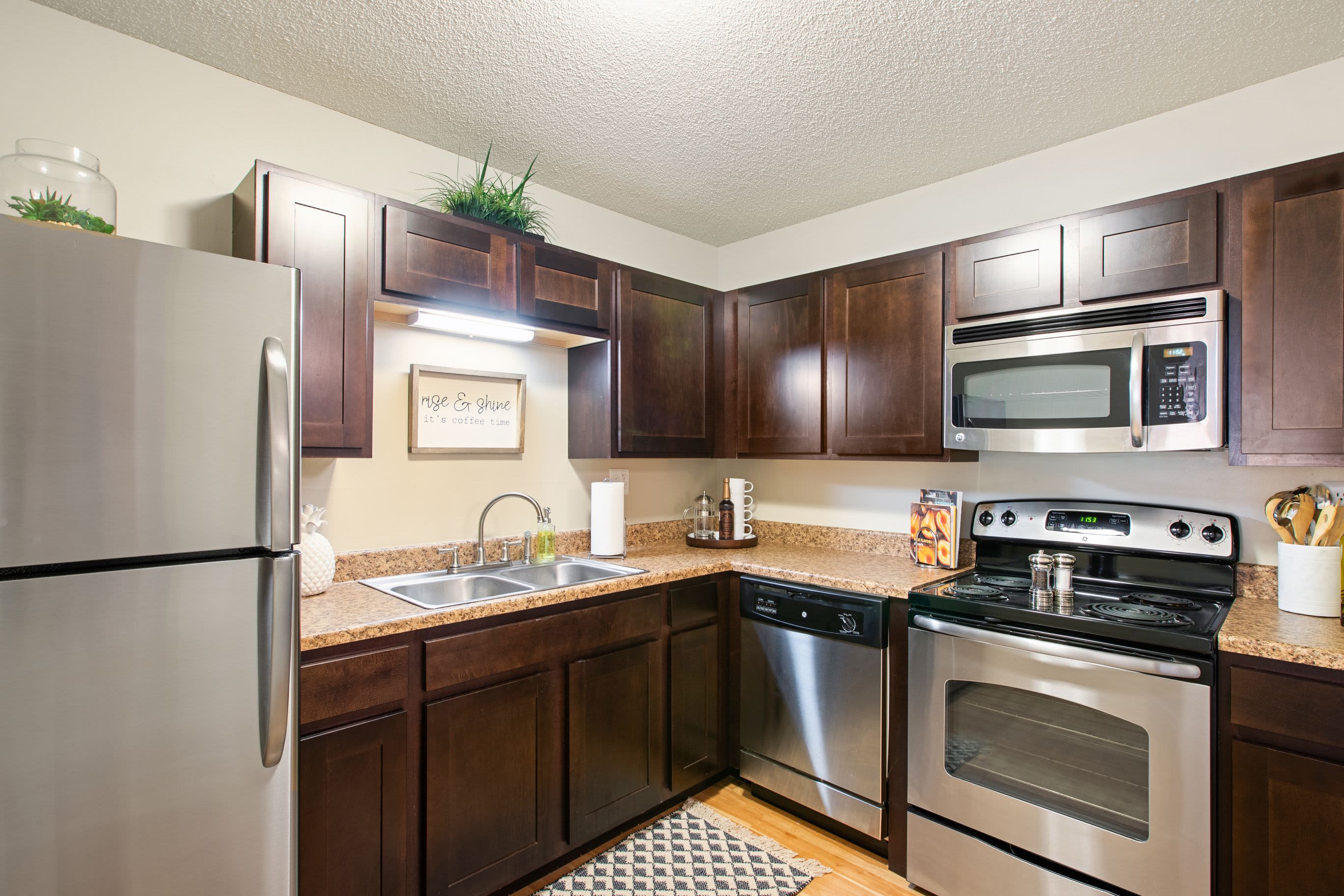 Kitchen with ample cabinetry and a stainless-steel refrigerator at Pointe West Apartment Homes in West Des Moines, Iowa
