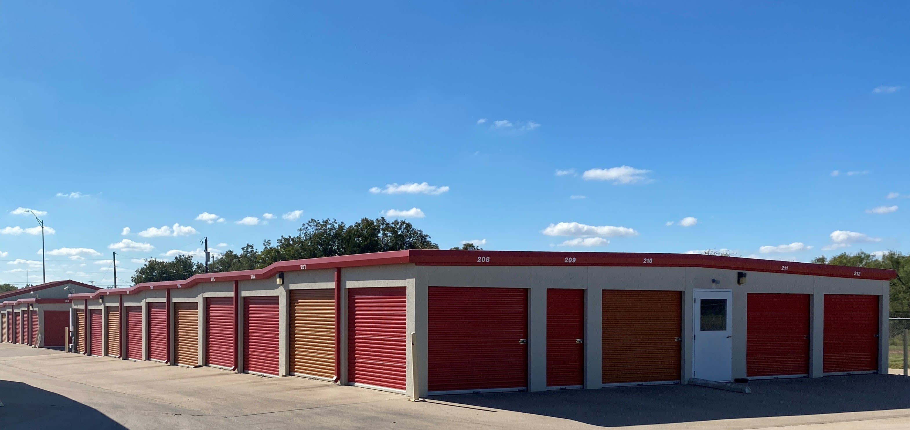 Exterior view of storage units with red and orange doors at KO Storage in Wichita Falls, Texas