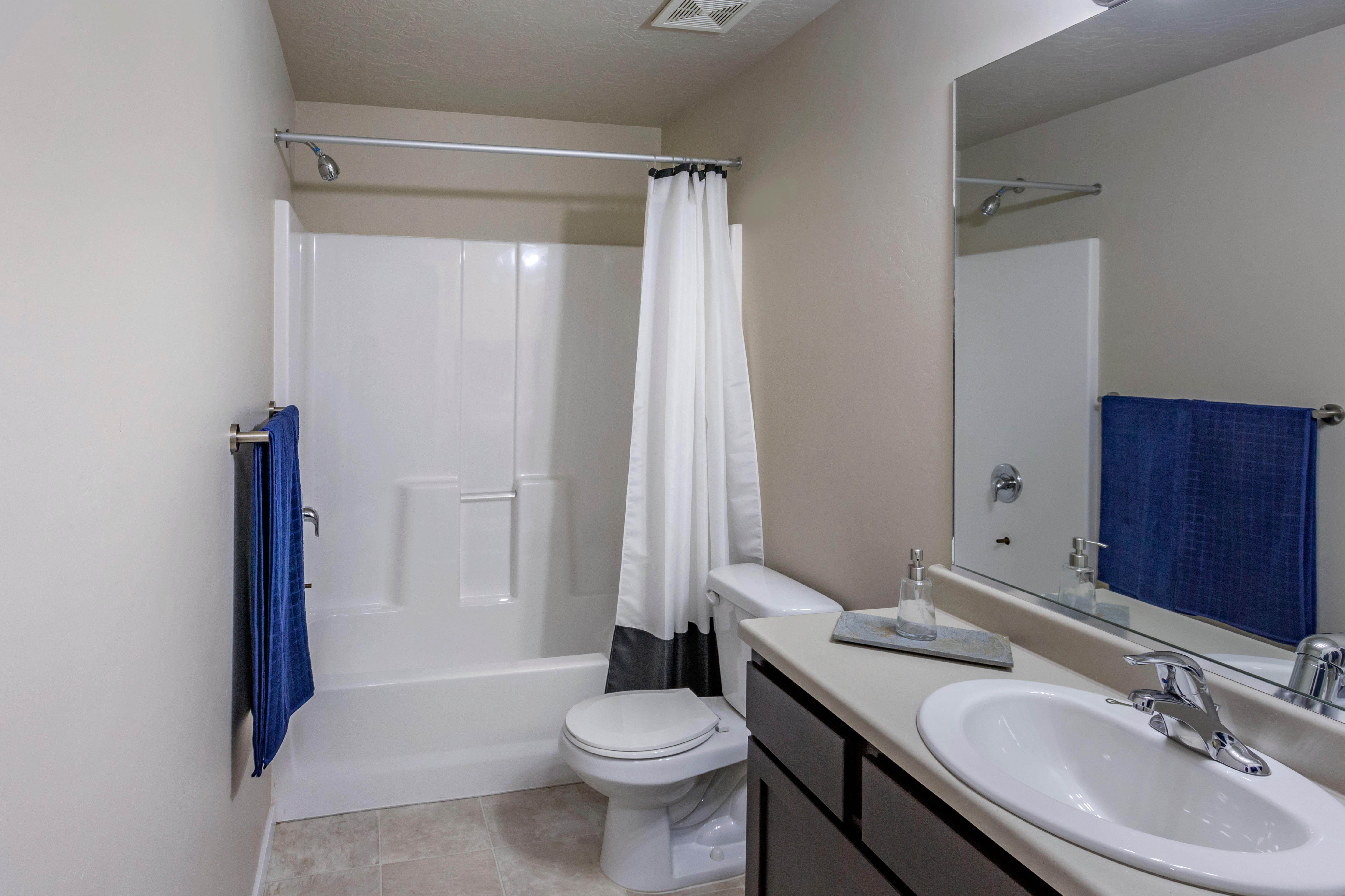Well-lit bathroom with vanity and tub and shower combination at Olympus at the Canyons in Herriman, Utah