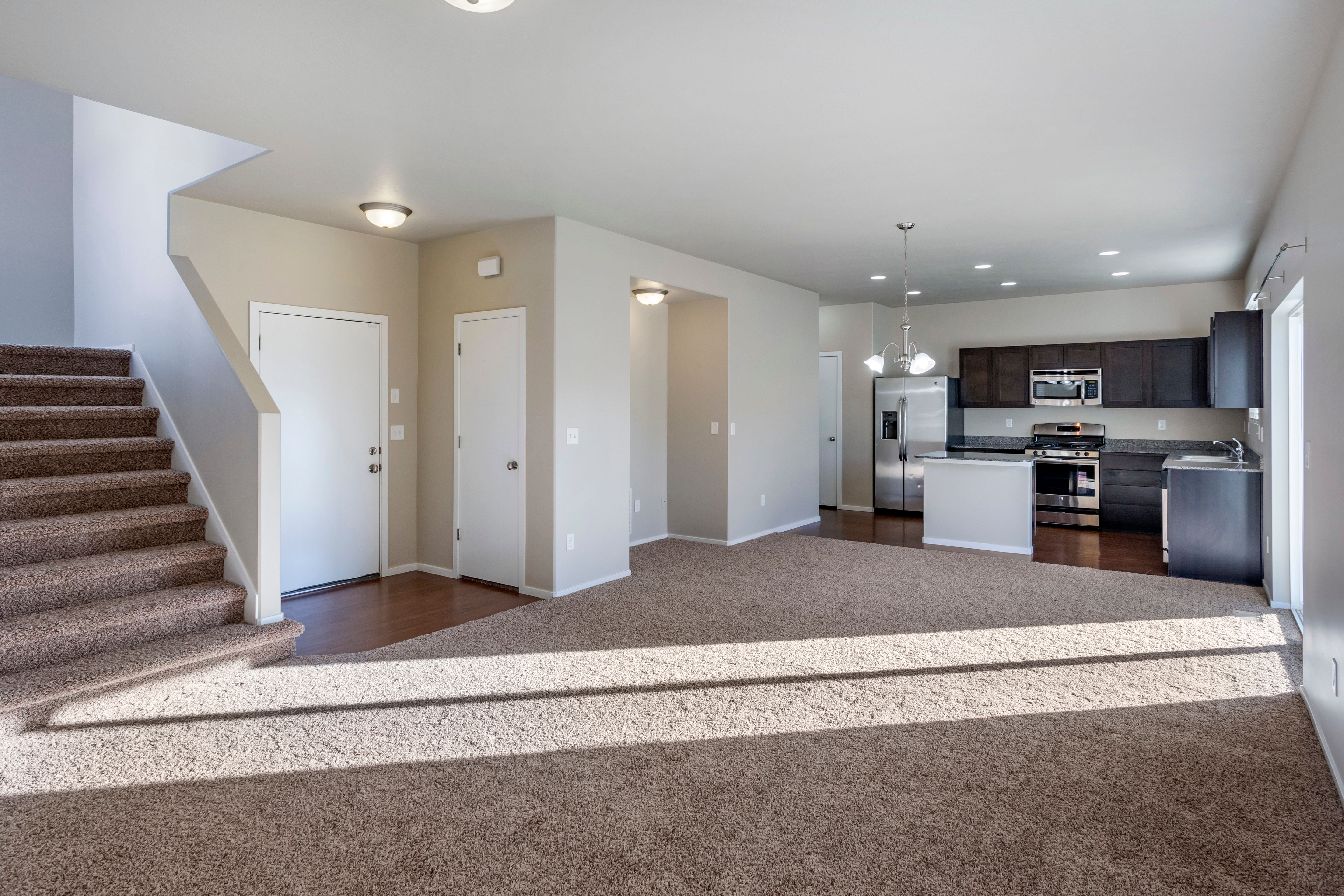 Spacious open concept living room, dining area, and kitchen at Olympus at the Canyons in Herriman, Utah