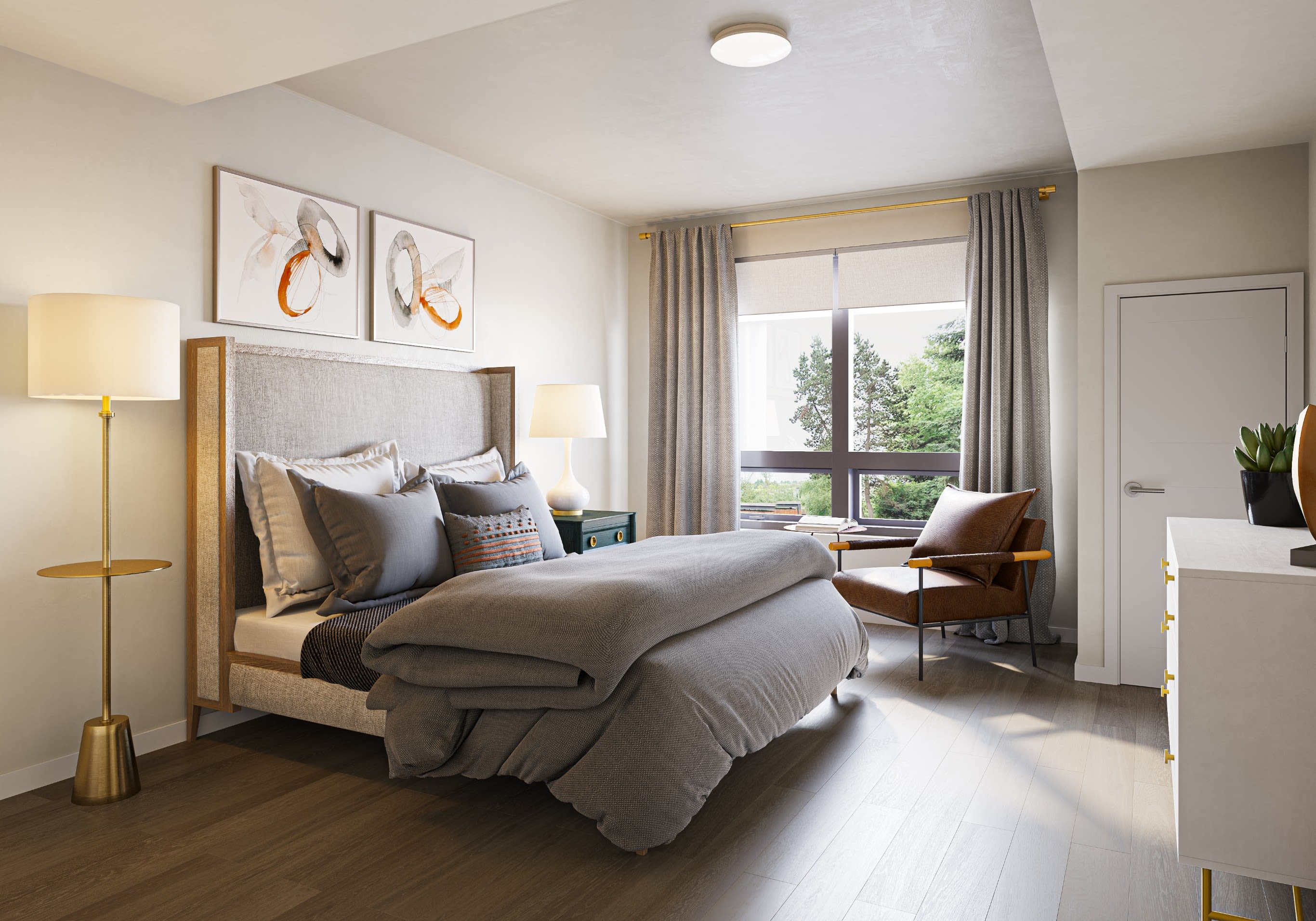 A model bedroom with large windows and hardwood floors at Holden of Bellevue in Bellevue, Washington