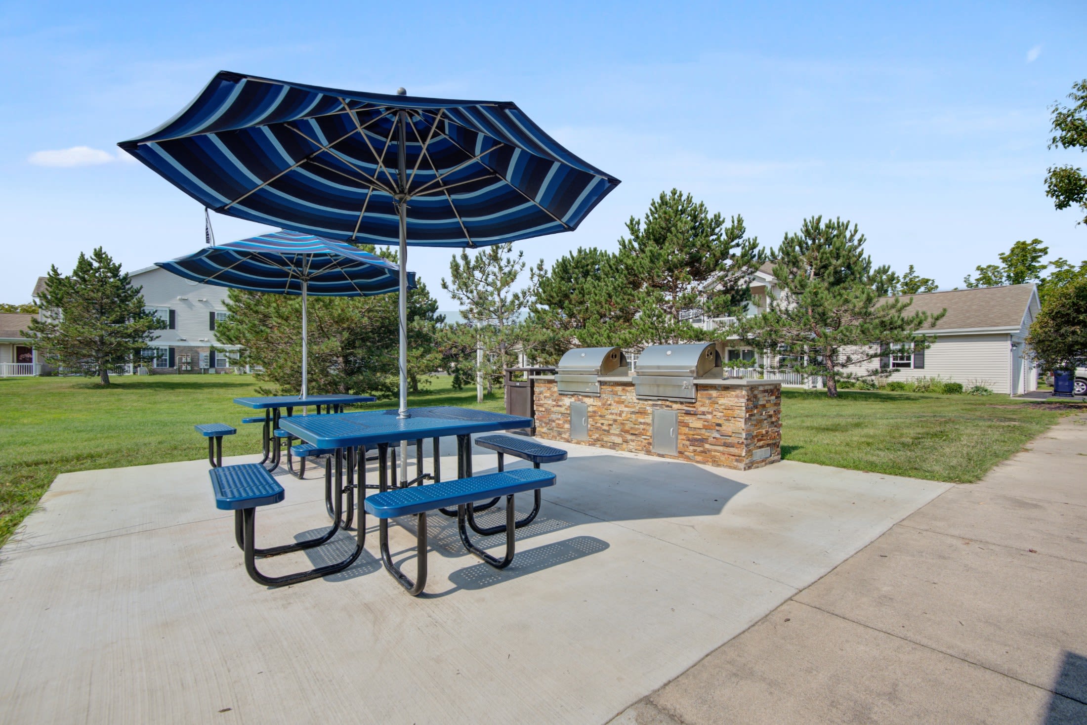 Picnic area and grilling stations at Oakmonte Apartments in Webster, New York
