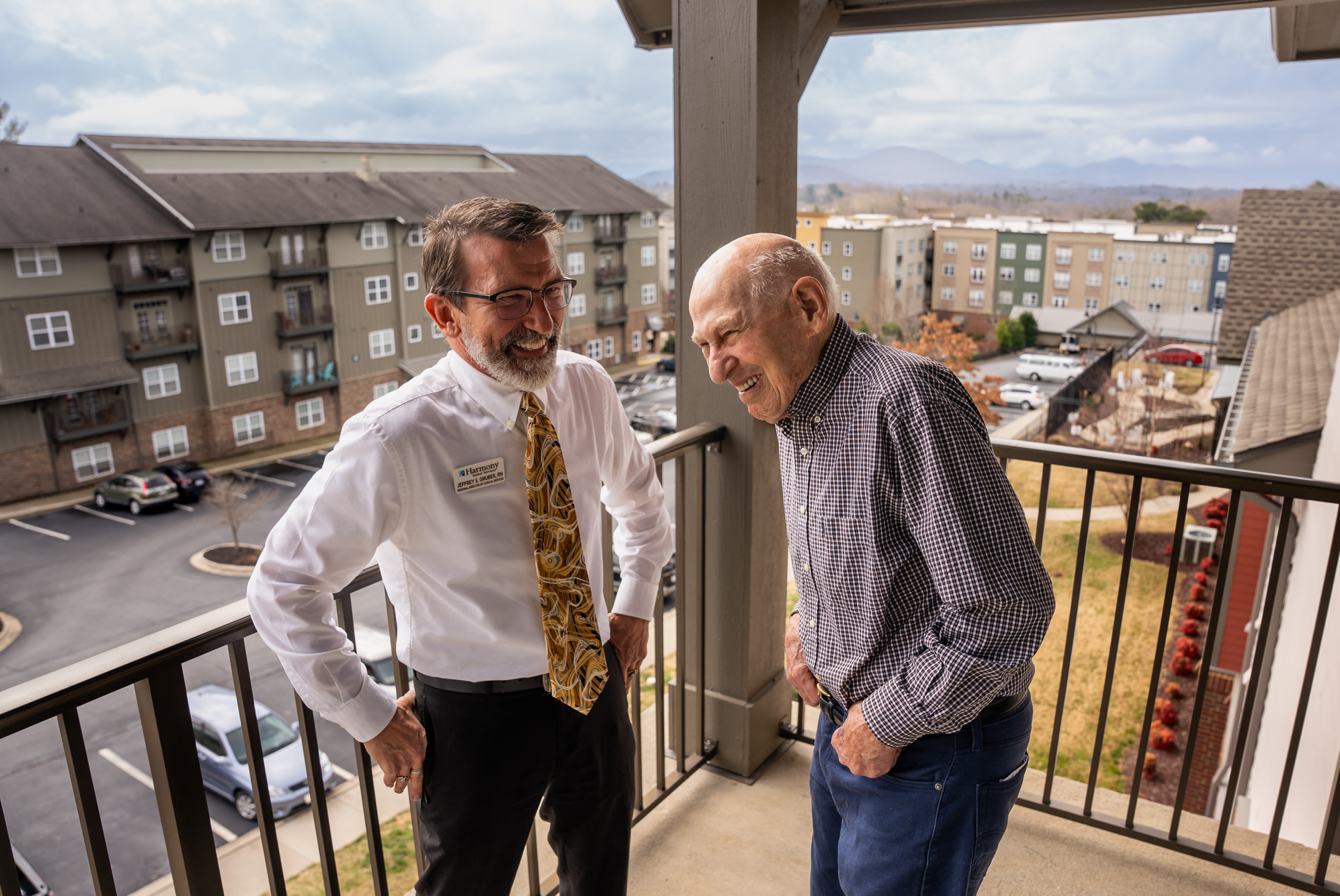 two men laughing on balcony at Harmony at Reynolds Mountain in Asheville, North Carolina
