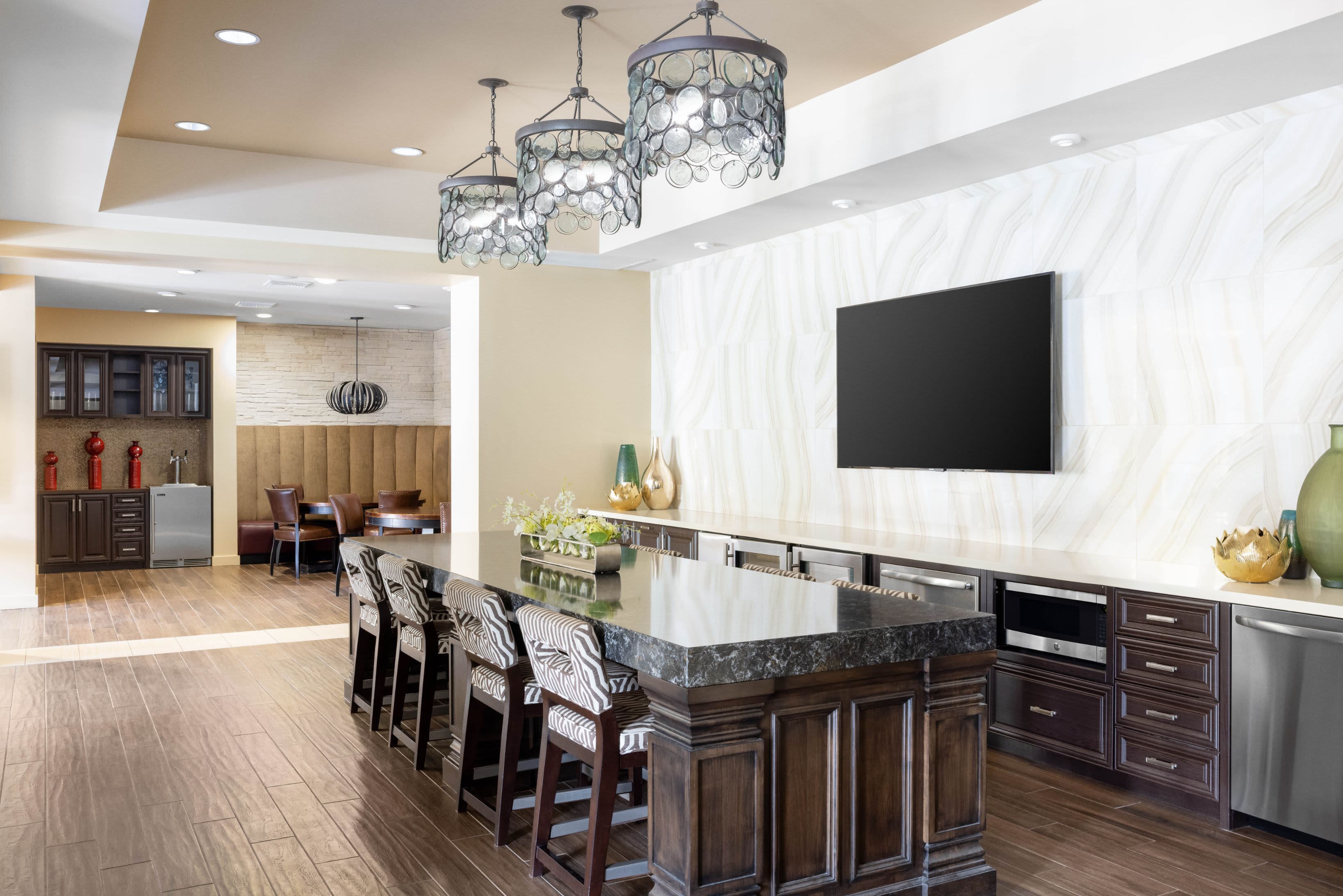 Clubhouse lounge with bar seating and flatscreen TVs at Vistara at SanTan Village in Gilbert, Arizona