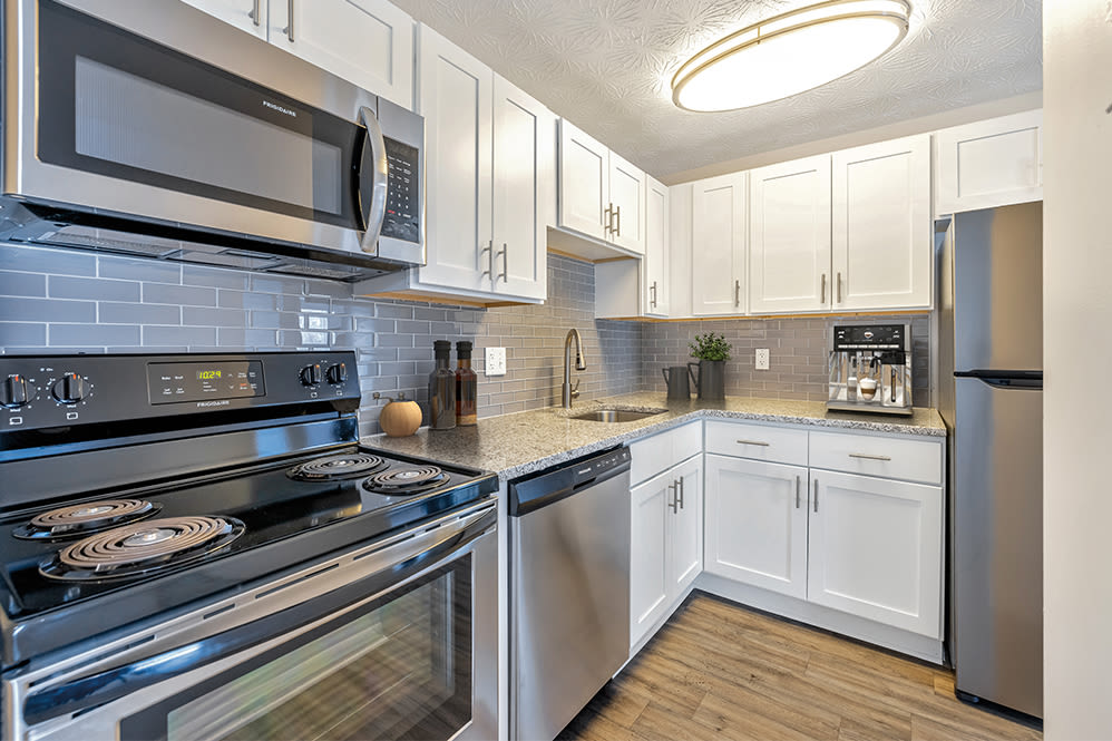 Fully equipped kitchen with white cabinet at Webster Manor Apartments in Webster, New York