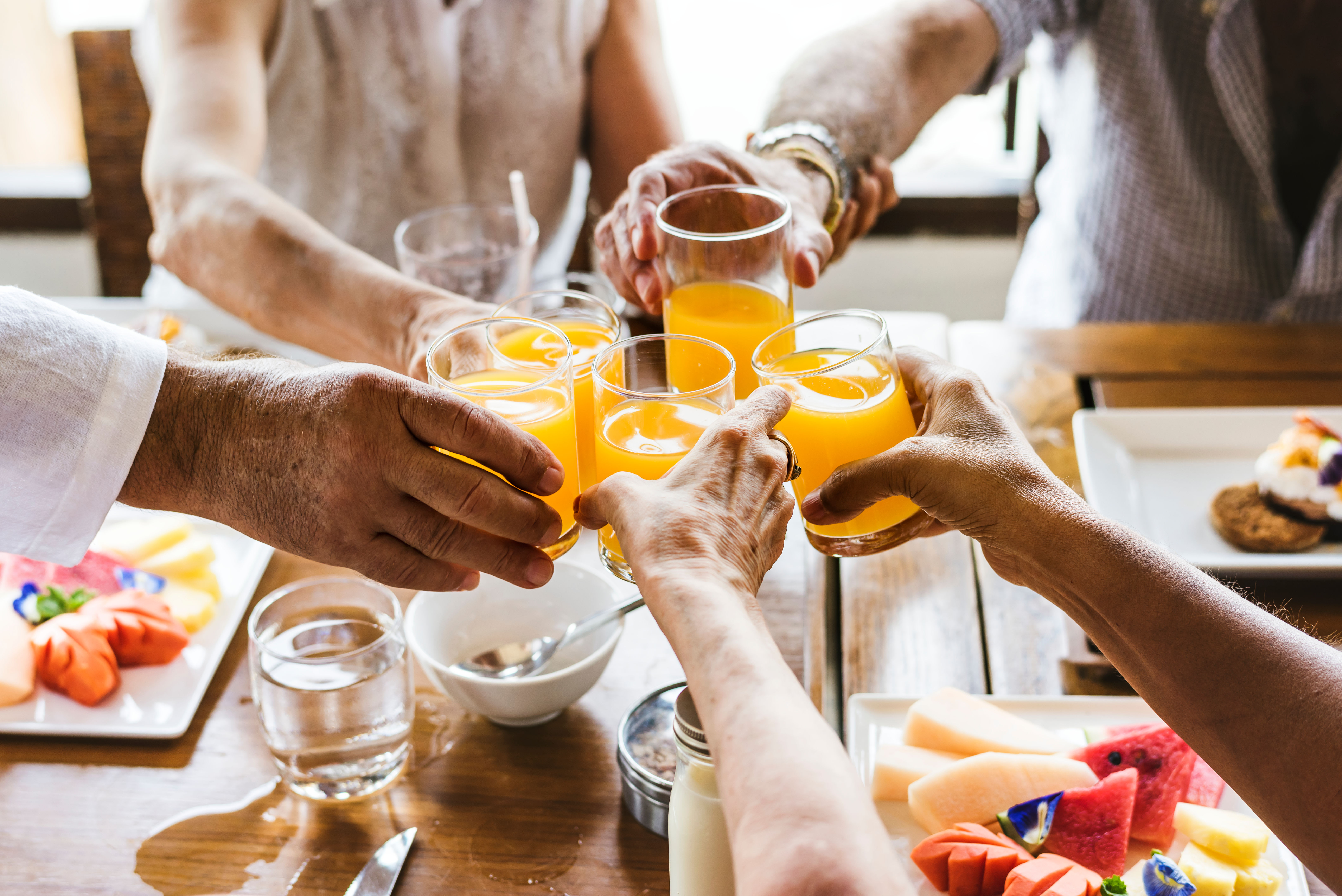 Residents toasting glasses of orange juice at English Meadows Laurens Campus in Laurens, South Carolina
