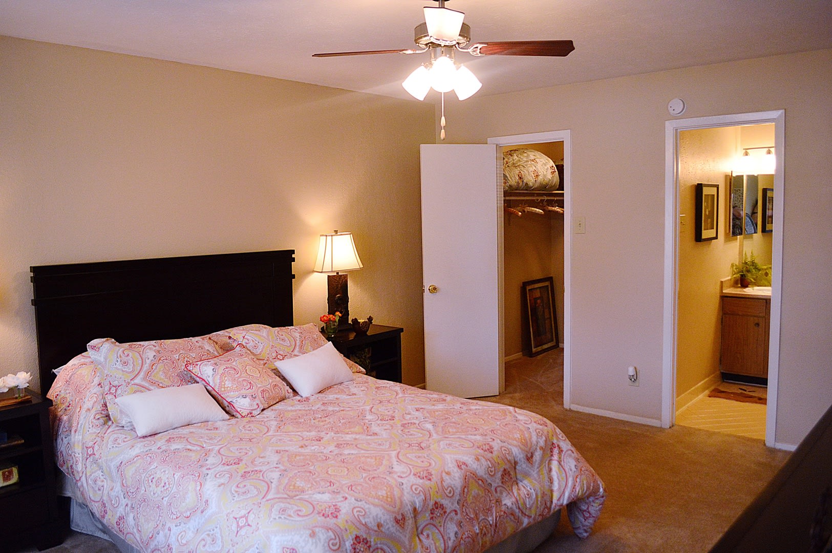 An apartment bedroom with a ceiling fan and walk-in closet at Villa Bella in Euless, Texas