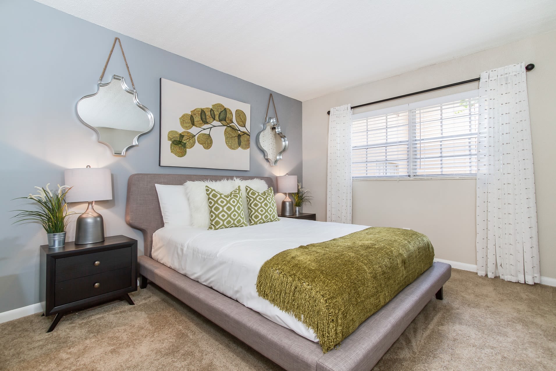 Spacious apartment bedroom with plush carpeting and large windows at Central Place at Winter Park in Winter Park, Florida