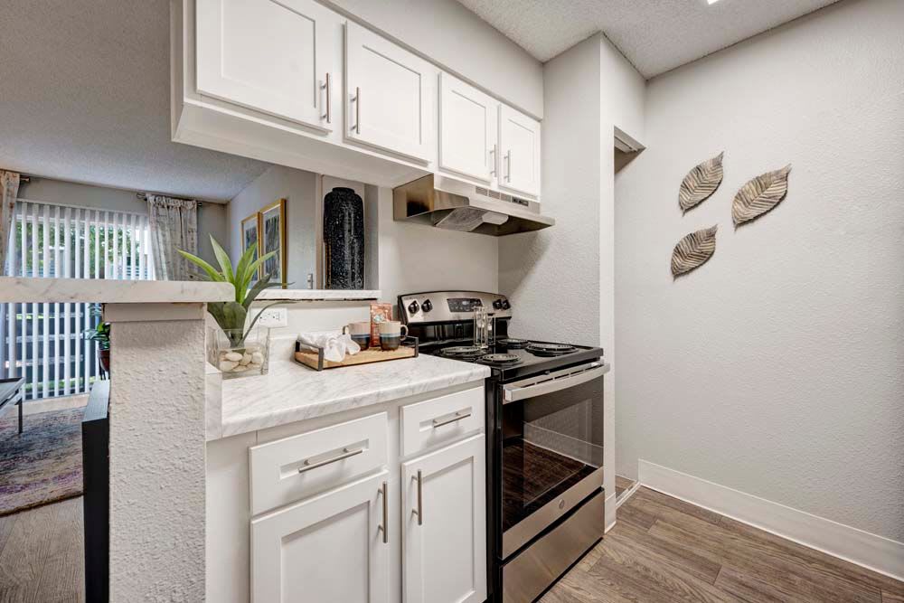 Spacious kitchen at Hampden Heights Apartments in Denver, Colorado with ample natural light featuring white cabinets 