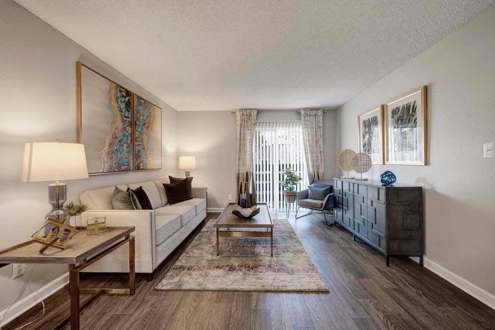Living room at Hampden Heights Apartments features a grey accent wall and couch with plus pillows and drapery