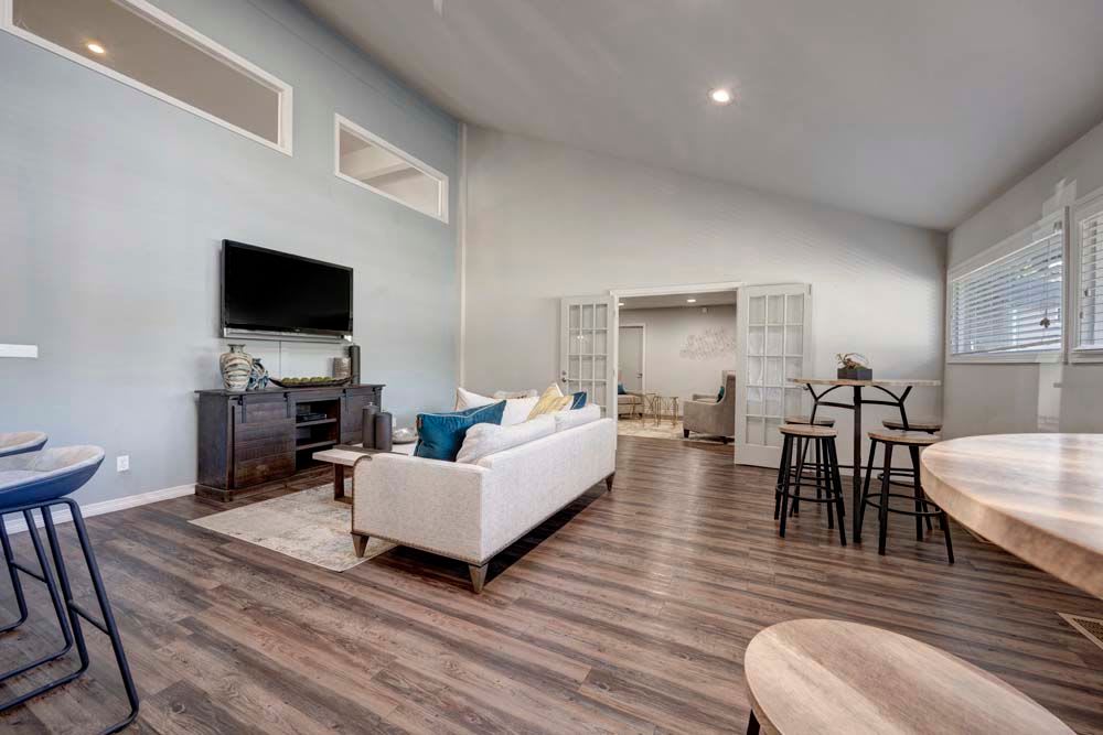Community gathering space with high top tables and large tv in clubhouse at Hampden Heights Apartments in Denver, Colorado