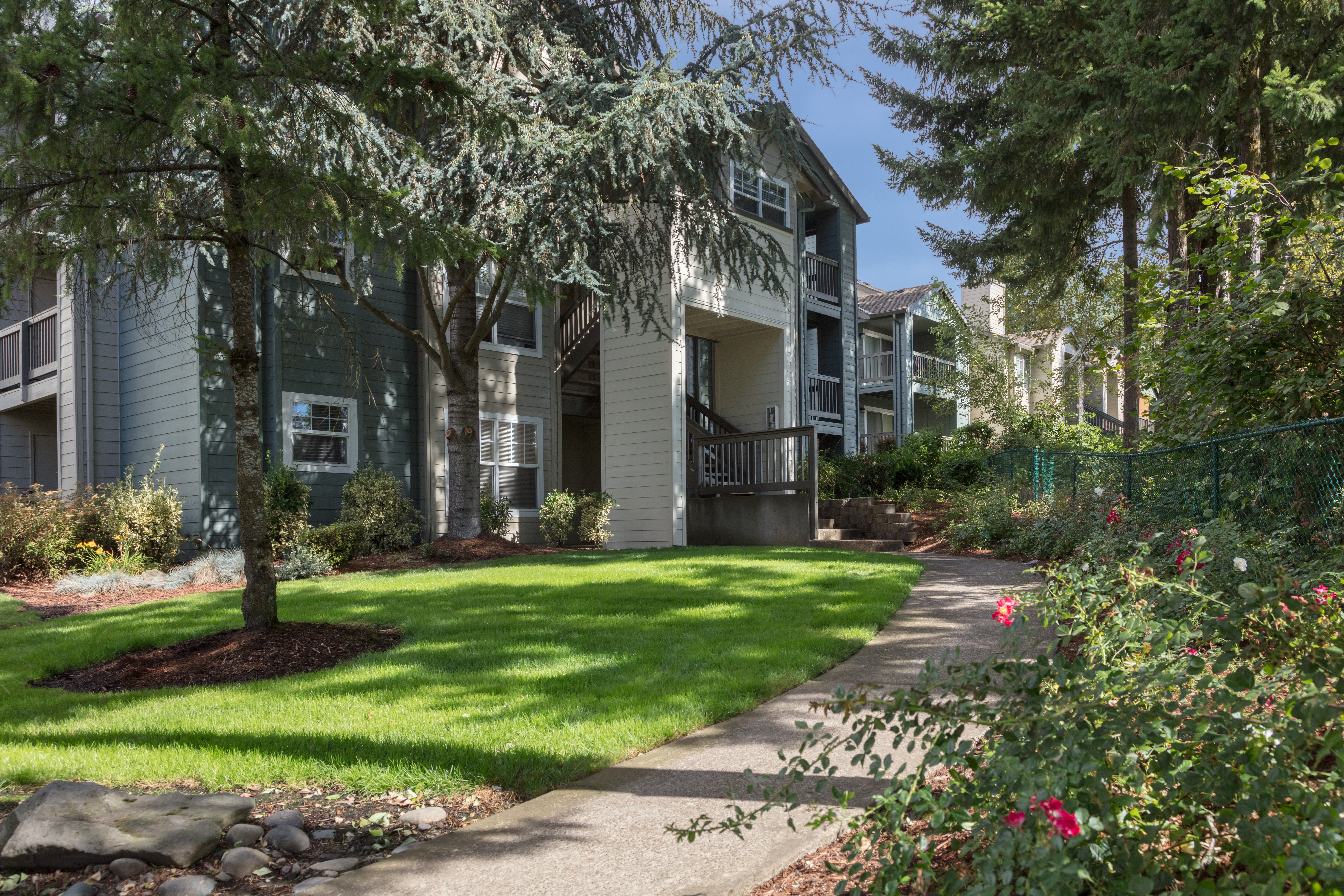 Well-maintained lawns and winding walkways outside resident buildings at Timbers at Tualatin in Tualatin, Oregon