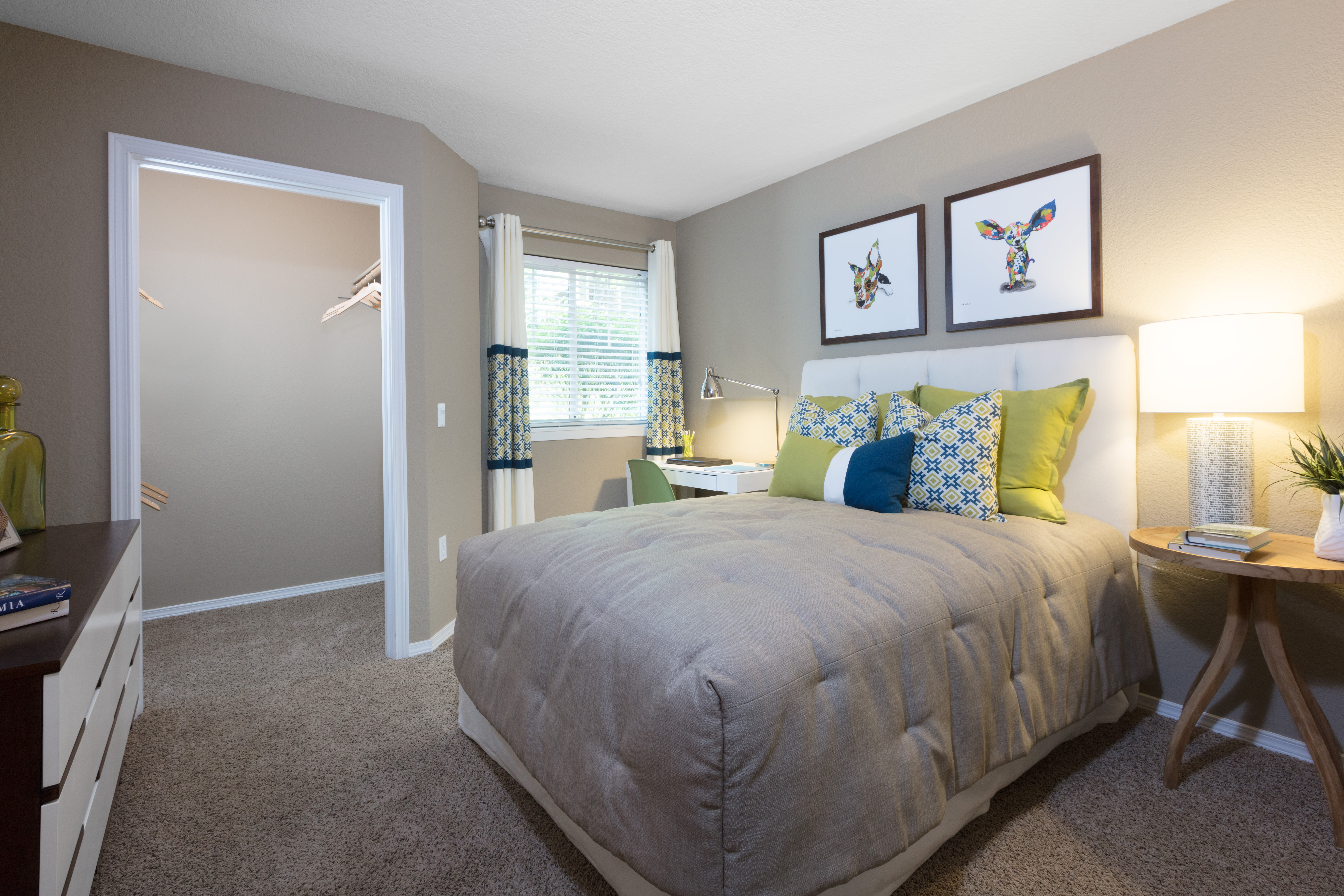 Master bedroom with draped windows and an accent wall in a model home at Timbers at Tualatin in Tualatin, Oregon
