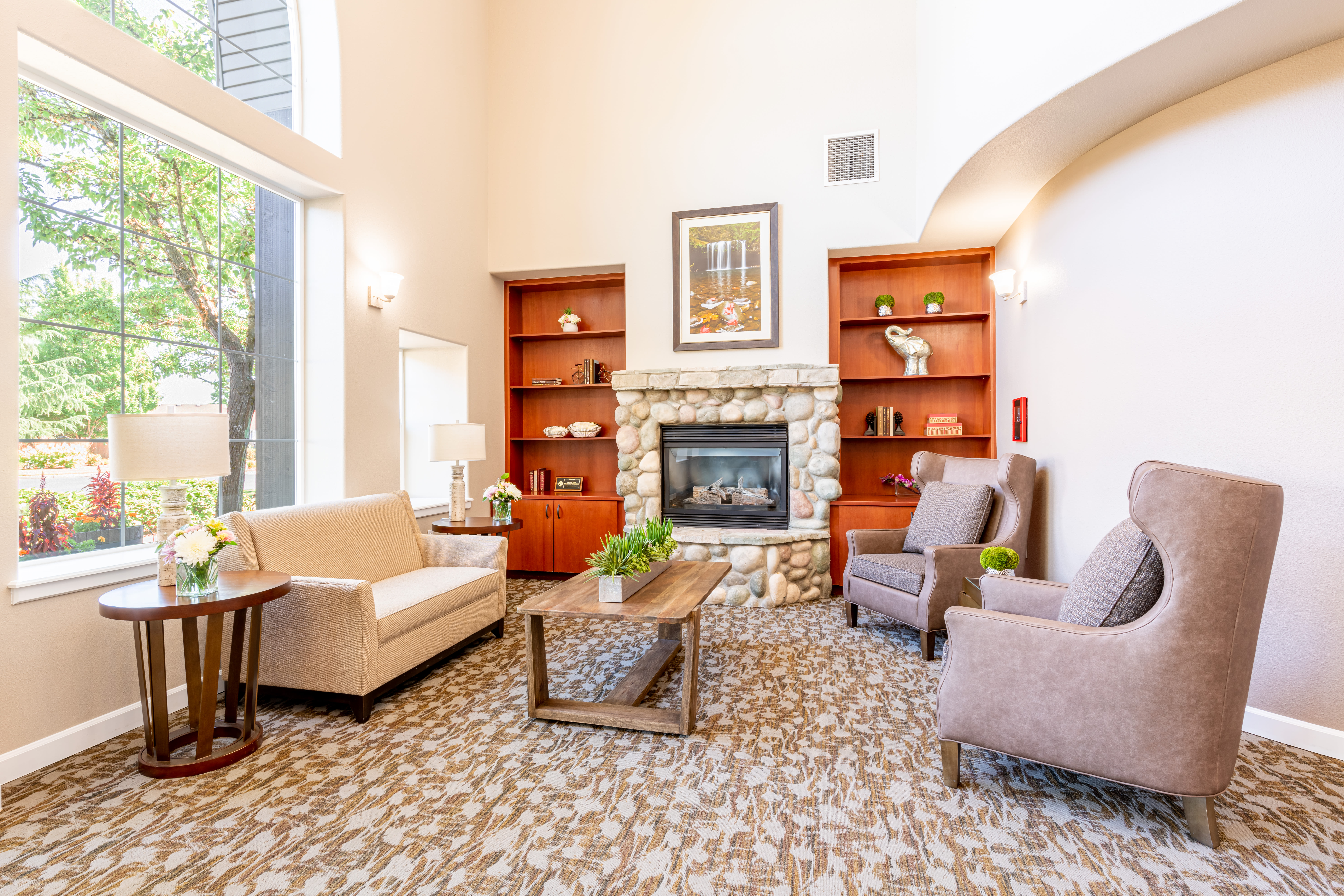 Cozy sitting area with bookcases and armchairs at Evergreen Memory Care in Eugene, Oregon. 