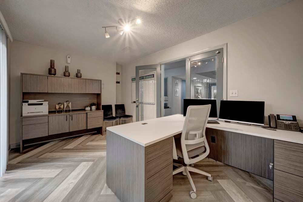 Leasing office desk with sliding glass doors leading outside at Arvada Green Apartment Homes in Arvada, Colorado