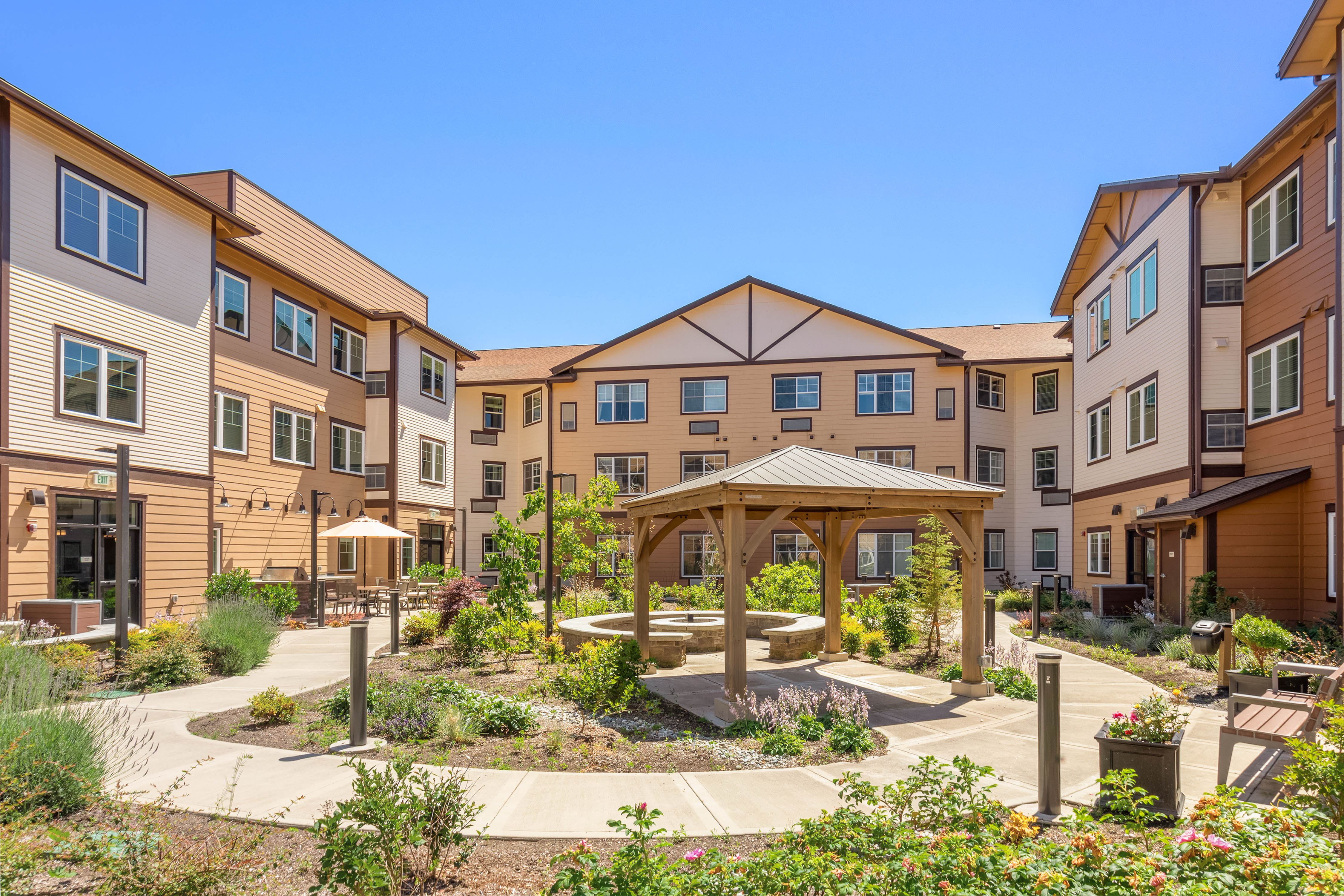 Outdoor courtyard with lots of landscaping and seating at Quail Park of Lynnwood in Lynnwood, Washington