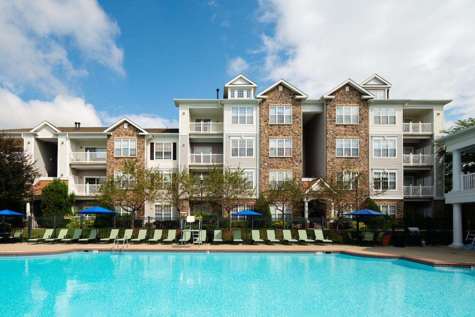 Resort-style swimming pool with a sundeck and lounge chairs at The Elms at Germantown in Germantown, Maryland