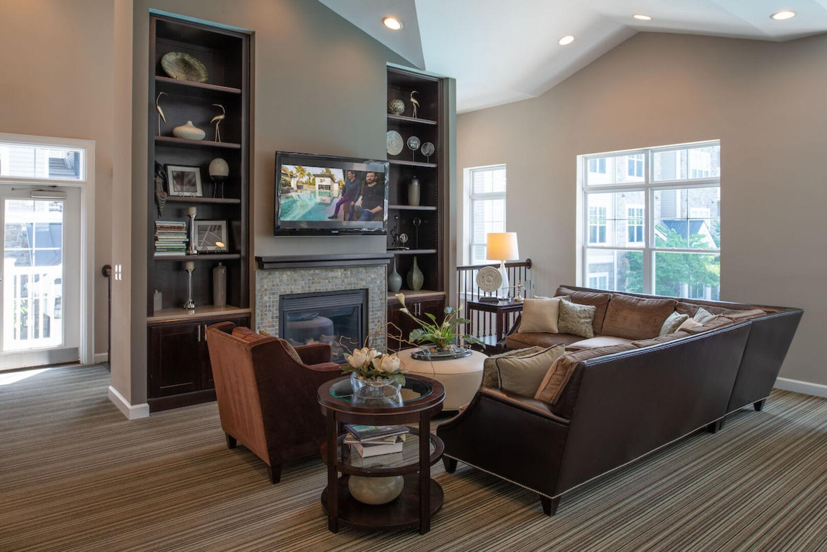 Community living area with TV, fireplace and sofas at The Elms at Stoney Run Village in Hanover, Maryland