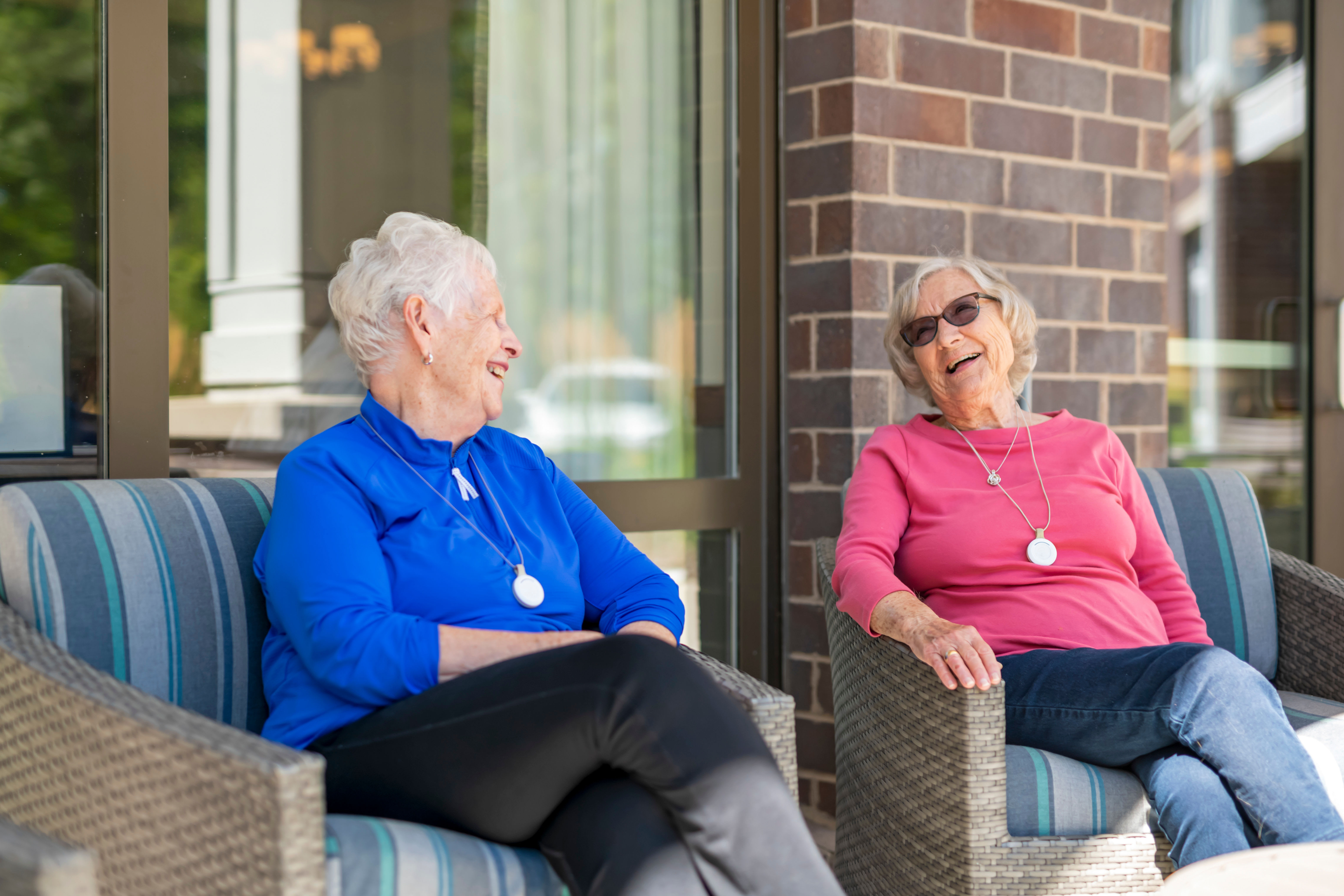 Two residents sitting outside having a conversation on a sunny day at Anthology Senior Living in Chicago, Illinois