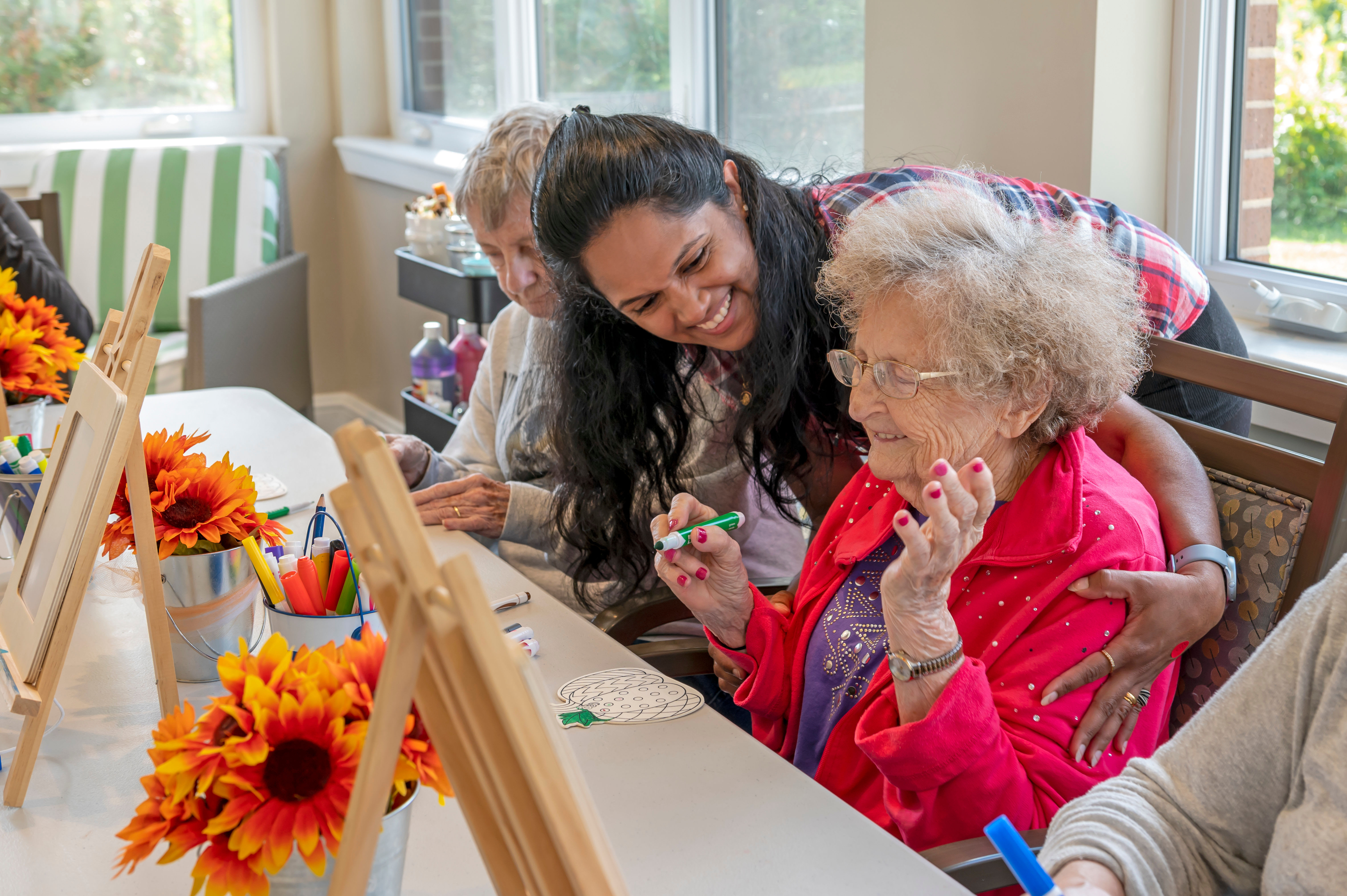 Resident and masked caretakers celebrating outside at Anthology of Edmonds in Edmonds, Washington