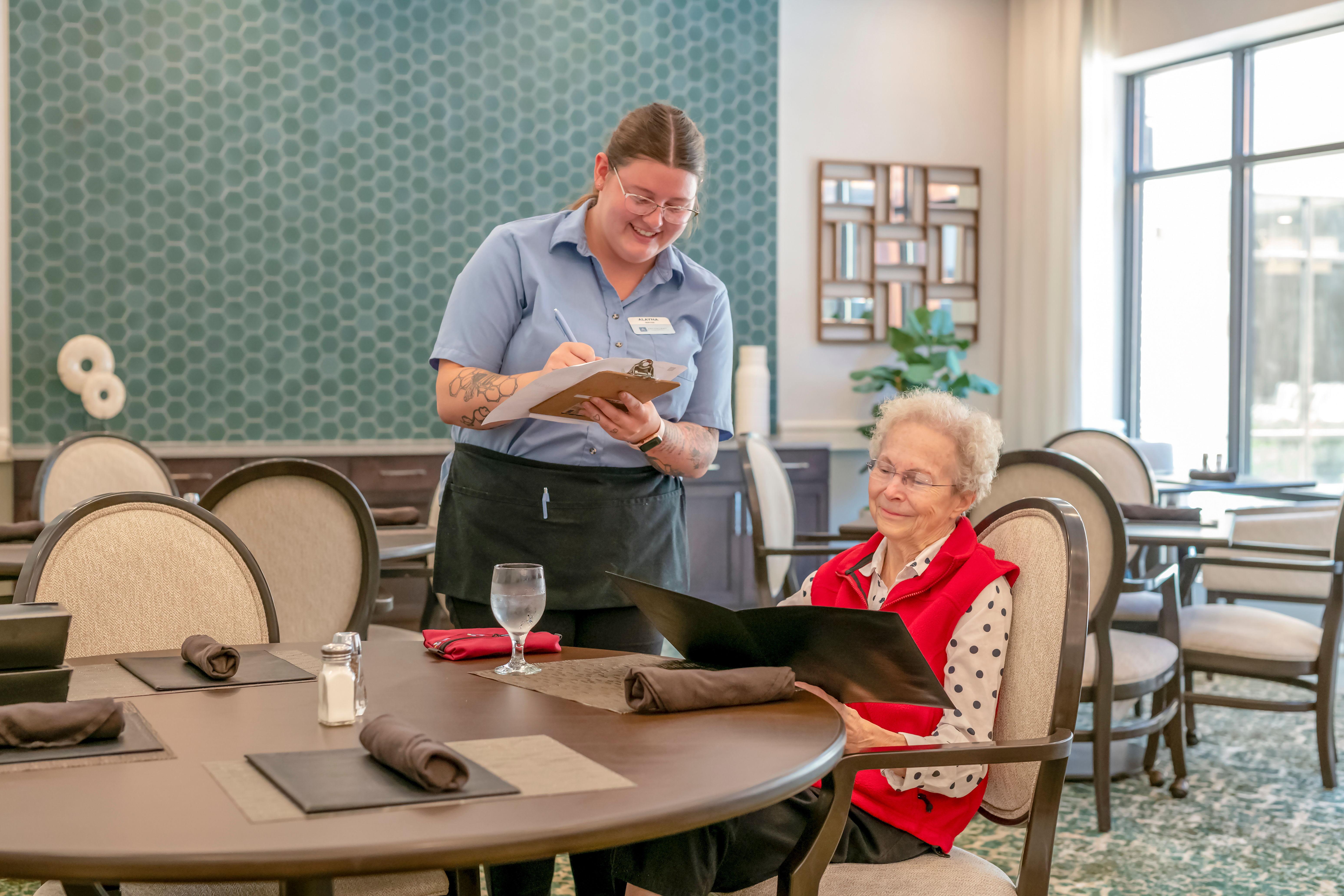 Caregiver taking a residents order in a thoughtfully decorated dining room at Anthology Senior Living in Chicago, Illinois