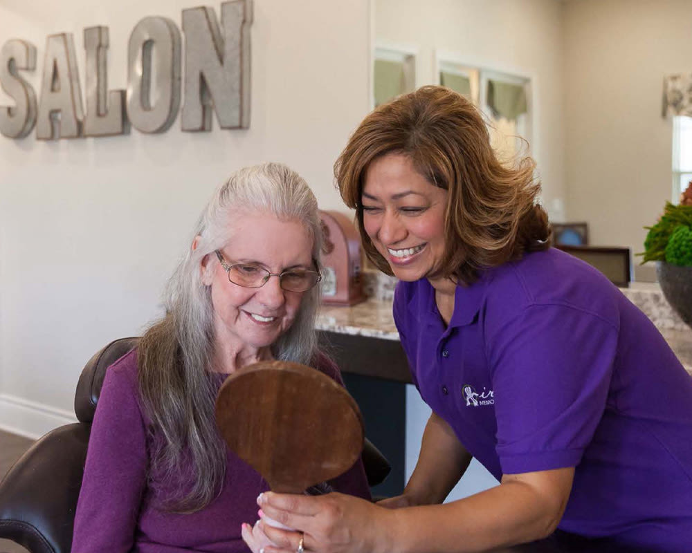 Staff member assisting resident in the salon at Iris Memory Care of Nichols Hills in Oklahoma City, Oklahoma. 