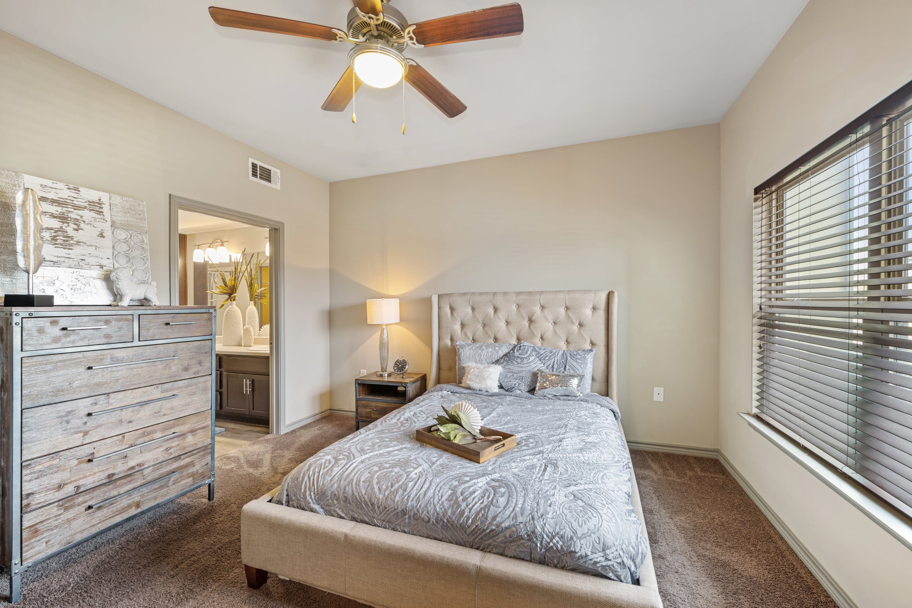 Model bedroom with cozy furnishings at The BLVD in San Angelo, Texas