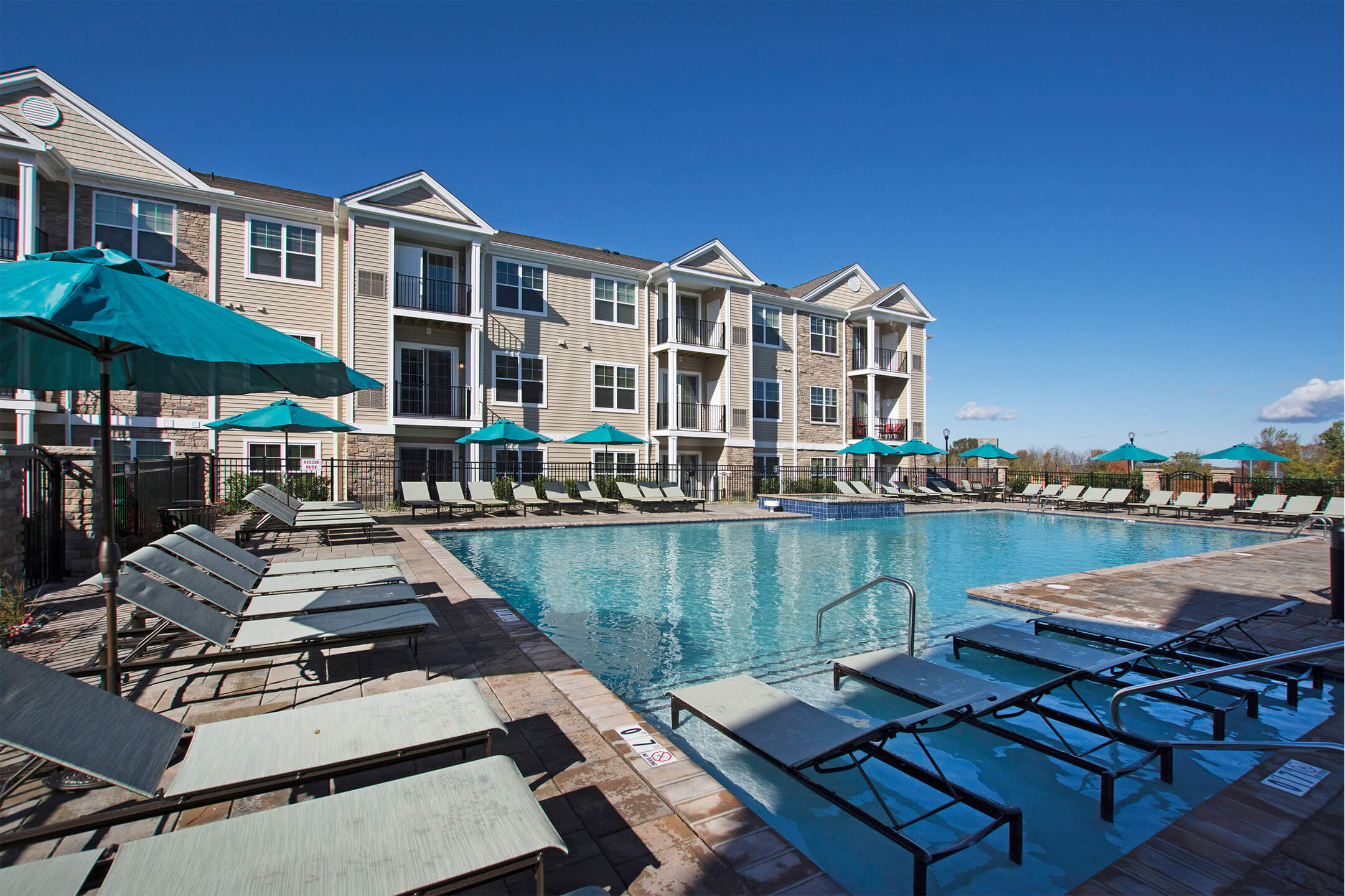 Outdoor poolside seating with umbrella at Parc at Roxbury, Roxbury Township, New Jersey